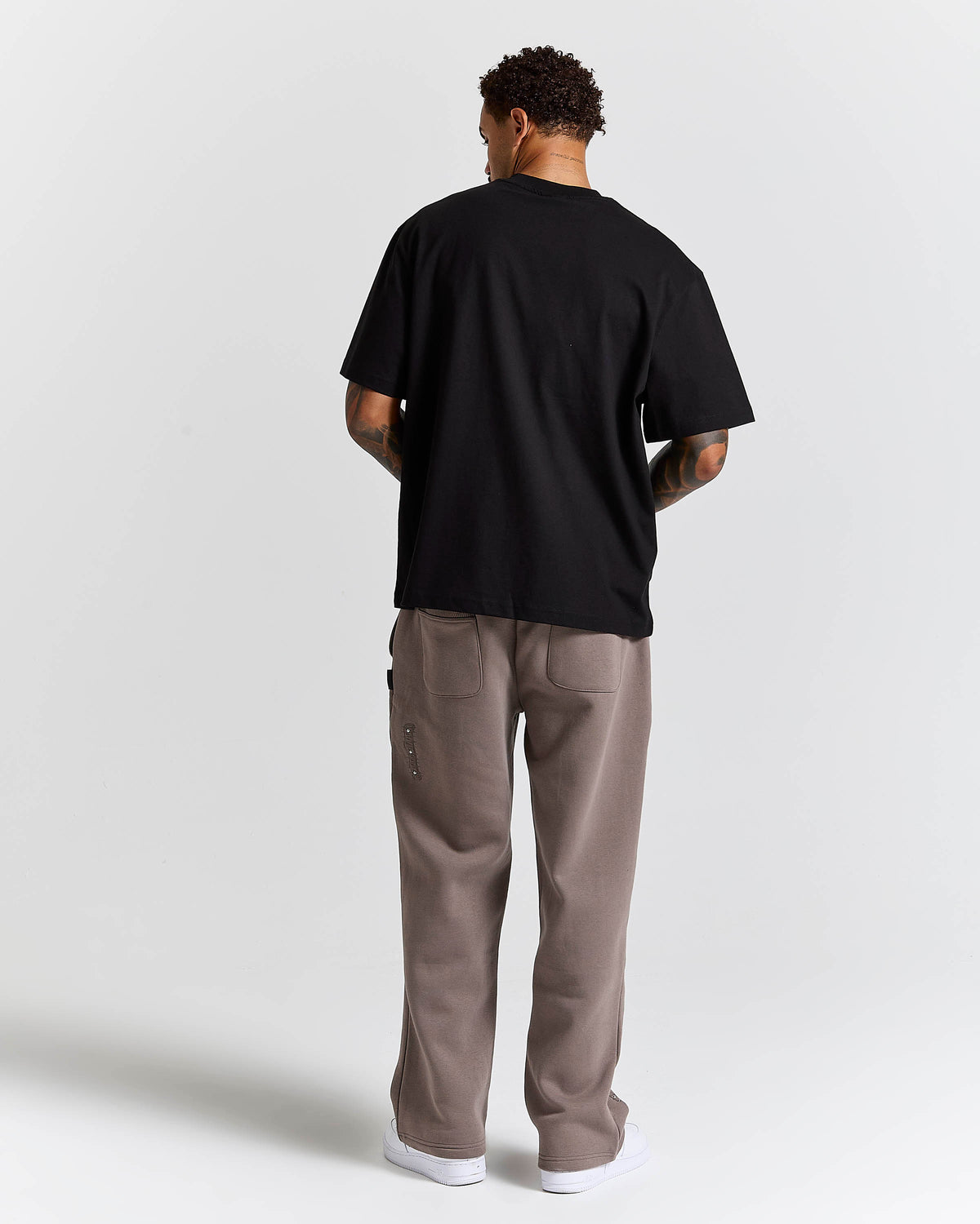 Displays a model wearing the Black 'Hoodrich' branded Inkline V2 Oversized Tshirt