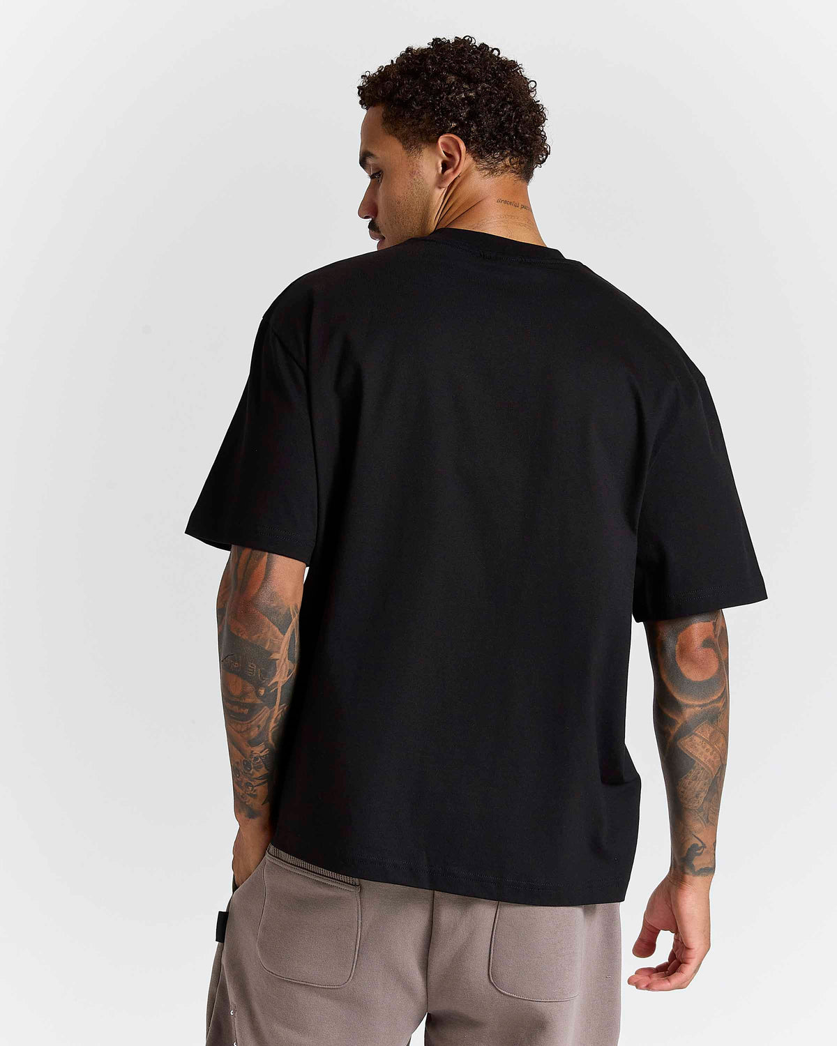 Displays a model wearing the Black 'Hoodrich' branded Inkline V2 Oversized Tshirt