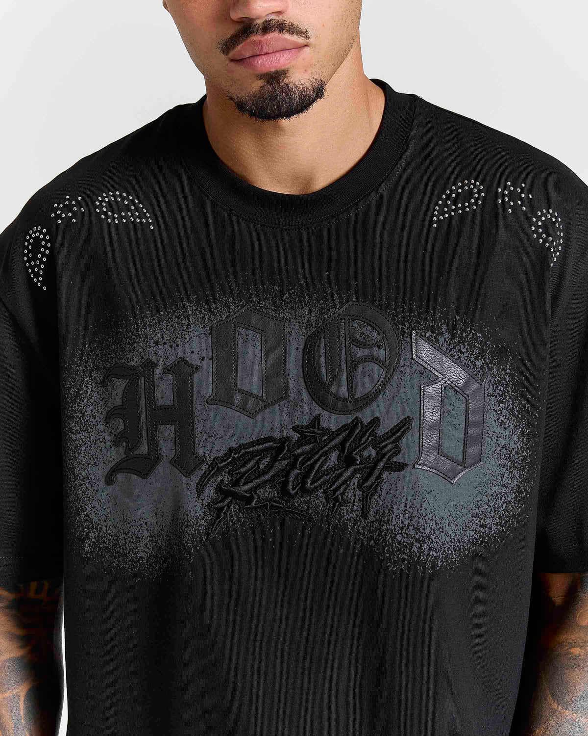 Displays a model wearing the Black 'Hoodrich' branded Inkline V2 Oversized Tshirt