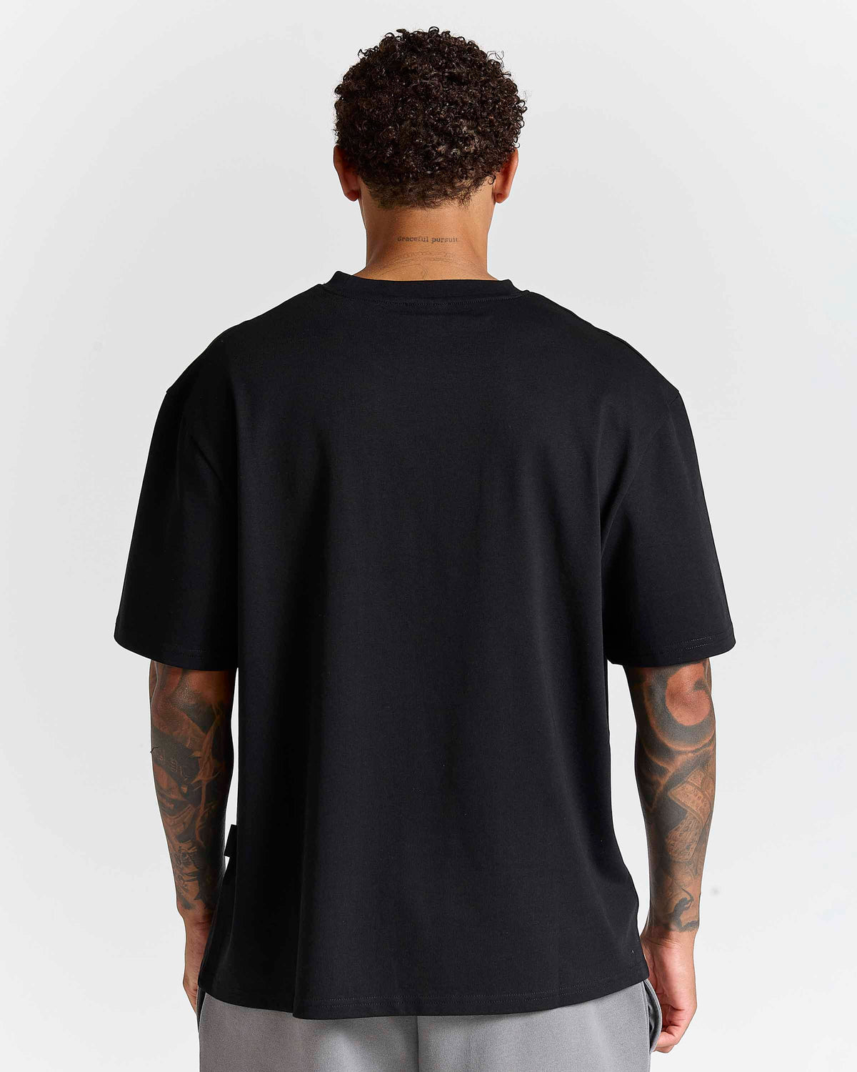 Displays a model wearing the Black lava smoke 'Hoodrich' branded Forza Oversized T-shirt