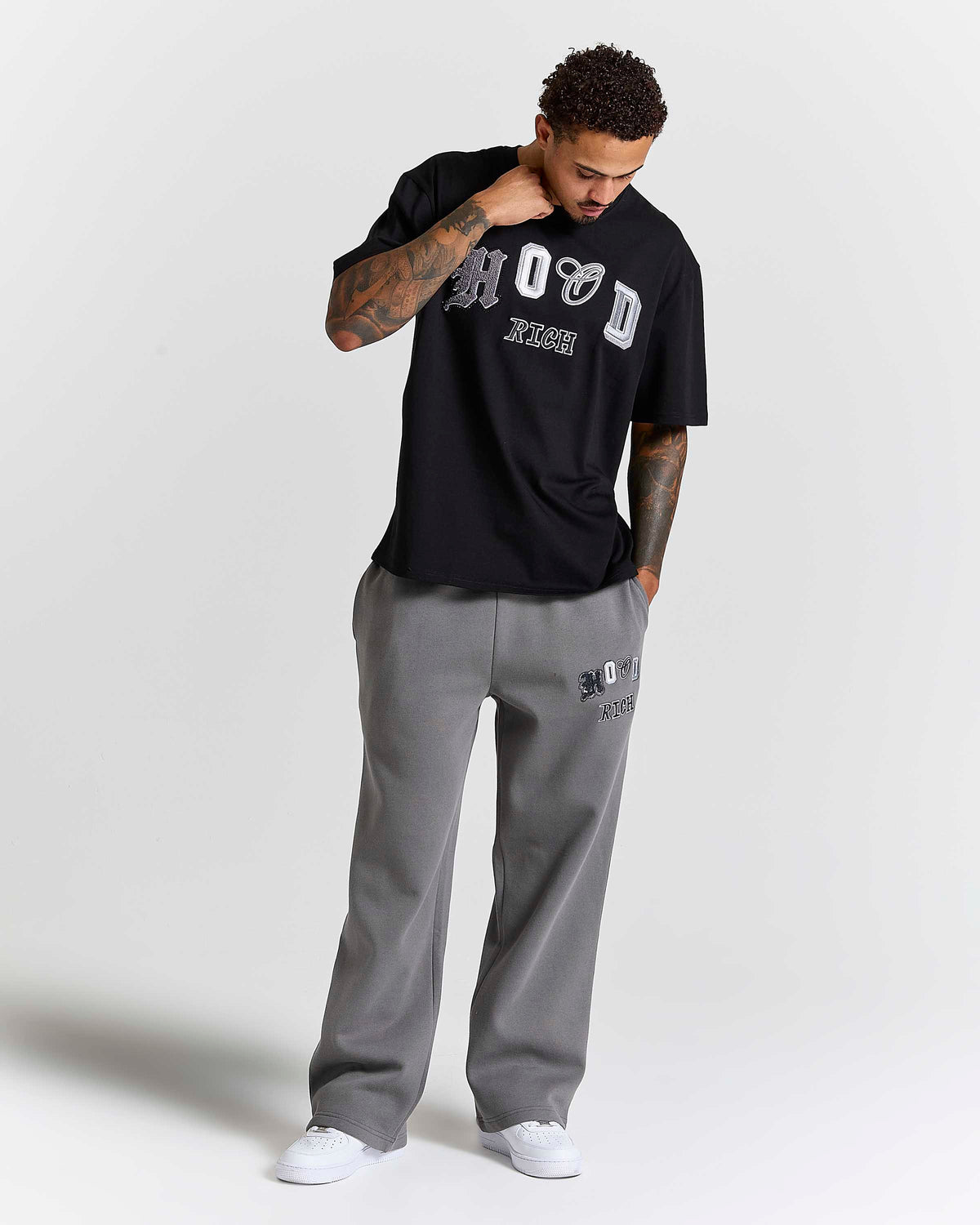 Displays a model wearing the Black lava smoke 'Hoodrich' branded Forza Oversized T-shirt
