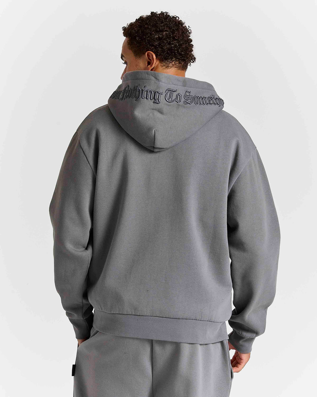 Displays a model wearing the Grey 'Hoodrich' branded men's Forza Full Tracksuit