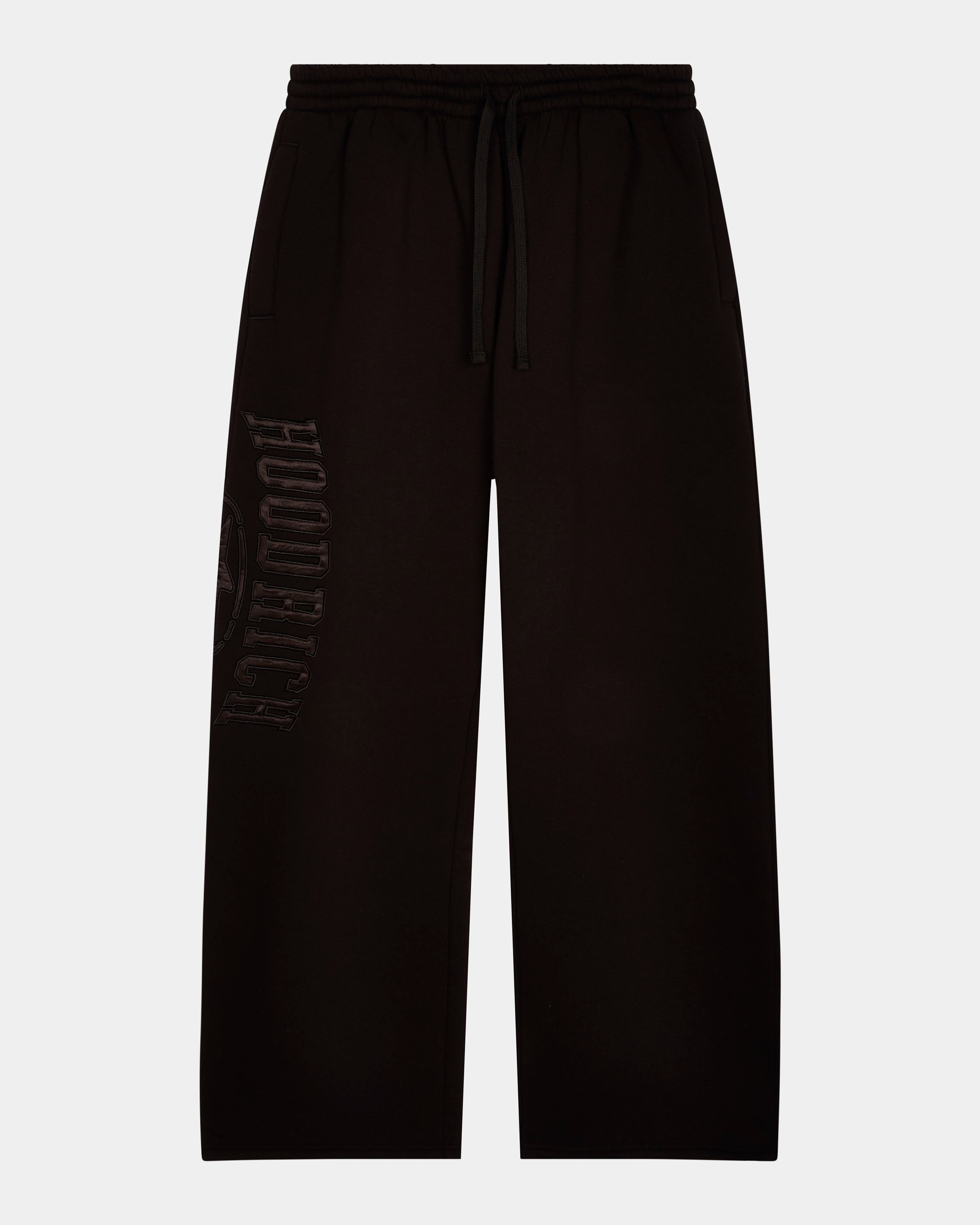 Black wide-leg sweatpants with a drawstring waist and a tonal vertical 'HOODRICH' logo printed on the left leg, shown against a light gray background.