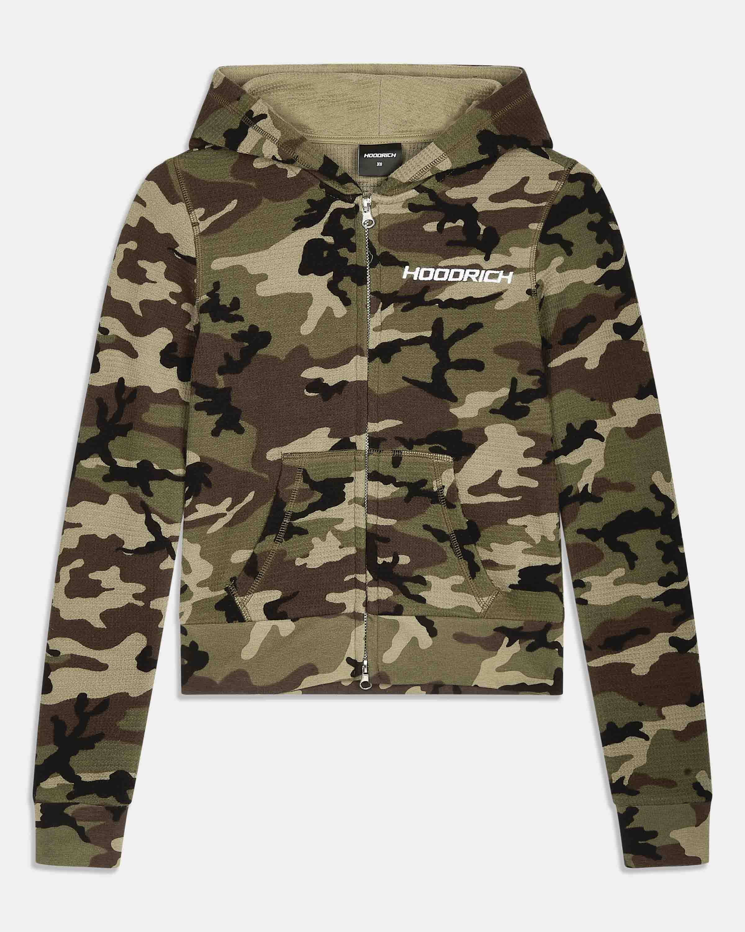 A cropped zip-up hoodie in a woodland camouflage pattern, featuring a white 'HOODRICH' logo printed on the left chest, displayed against a light gray background.
