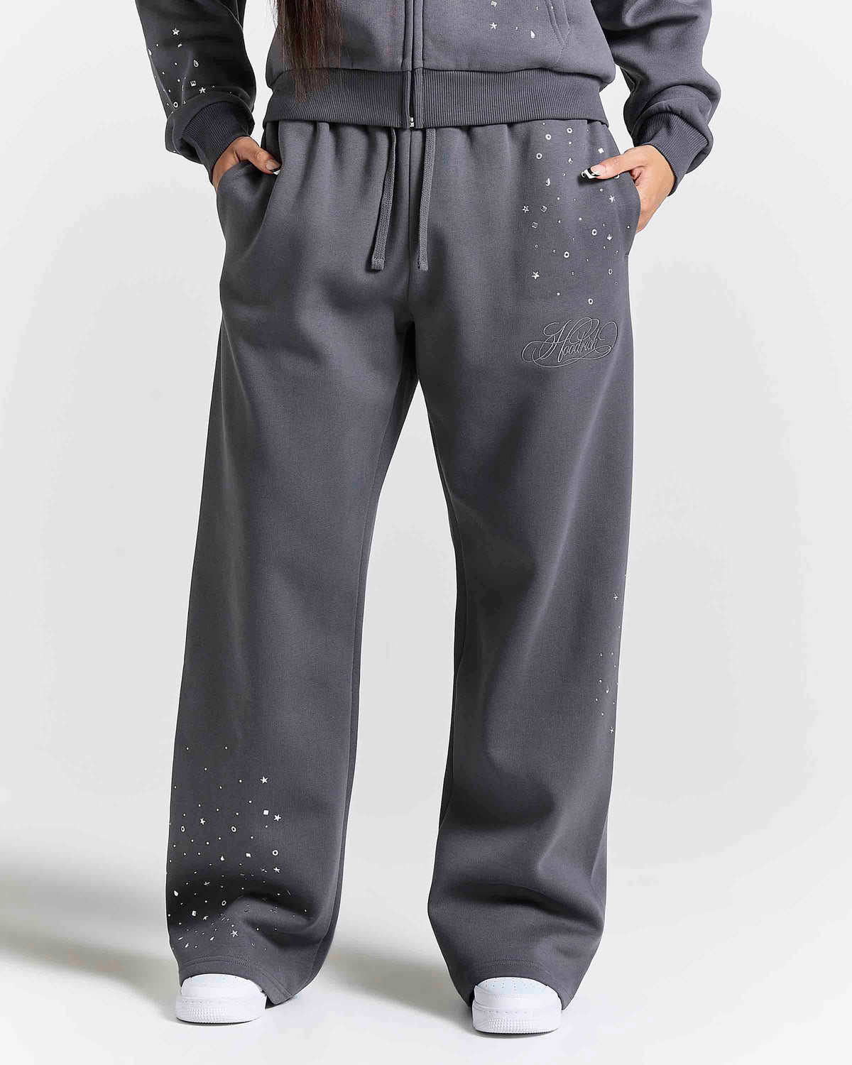Displays a model wearing the grey 'Hoodrich' branded women's Clash Full Tracksuit
