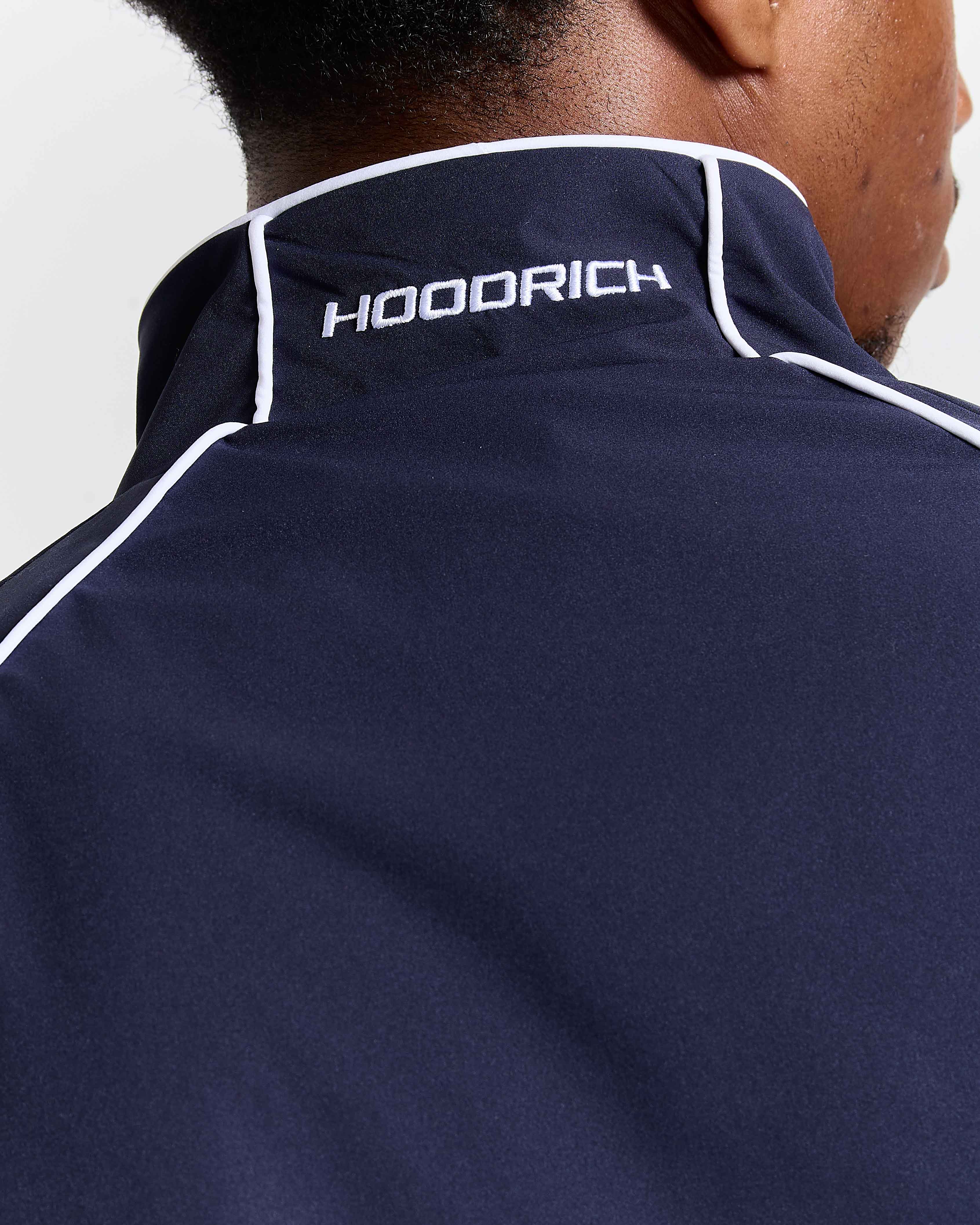 Navy blue jacket with 'HOODRICH' branding on the back against a white background
