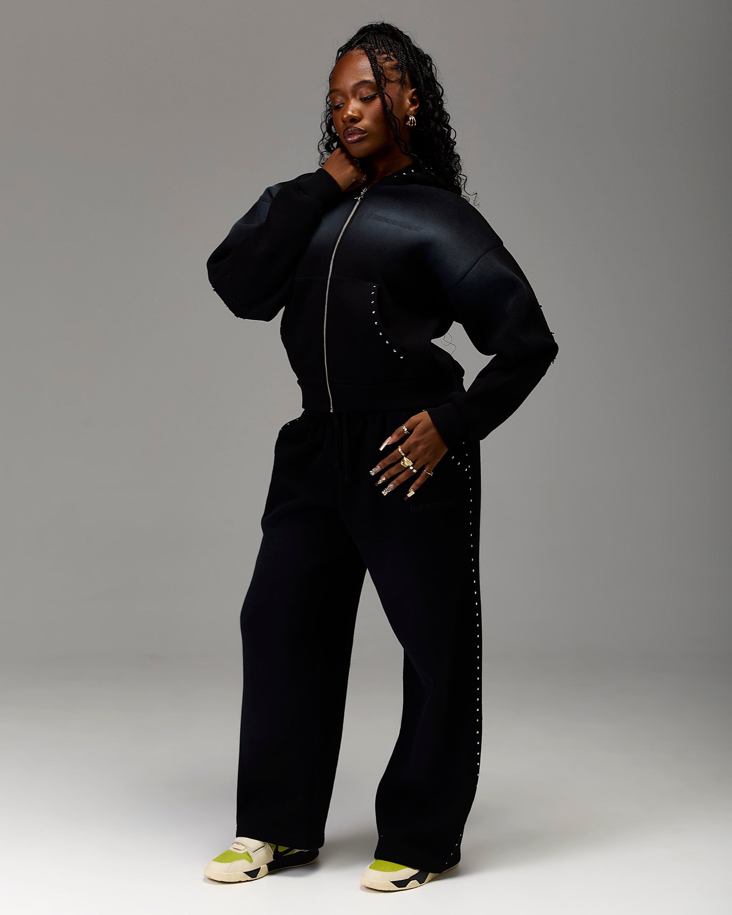 Displays a model wearing the Black 'Hoodrich' branded women's Winner's Circle Aspen Full Tracksuit