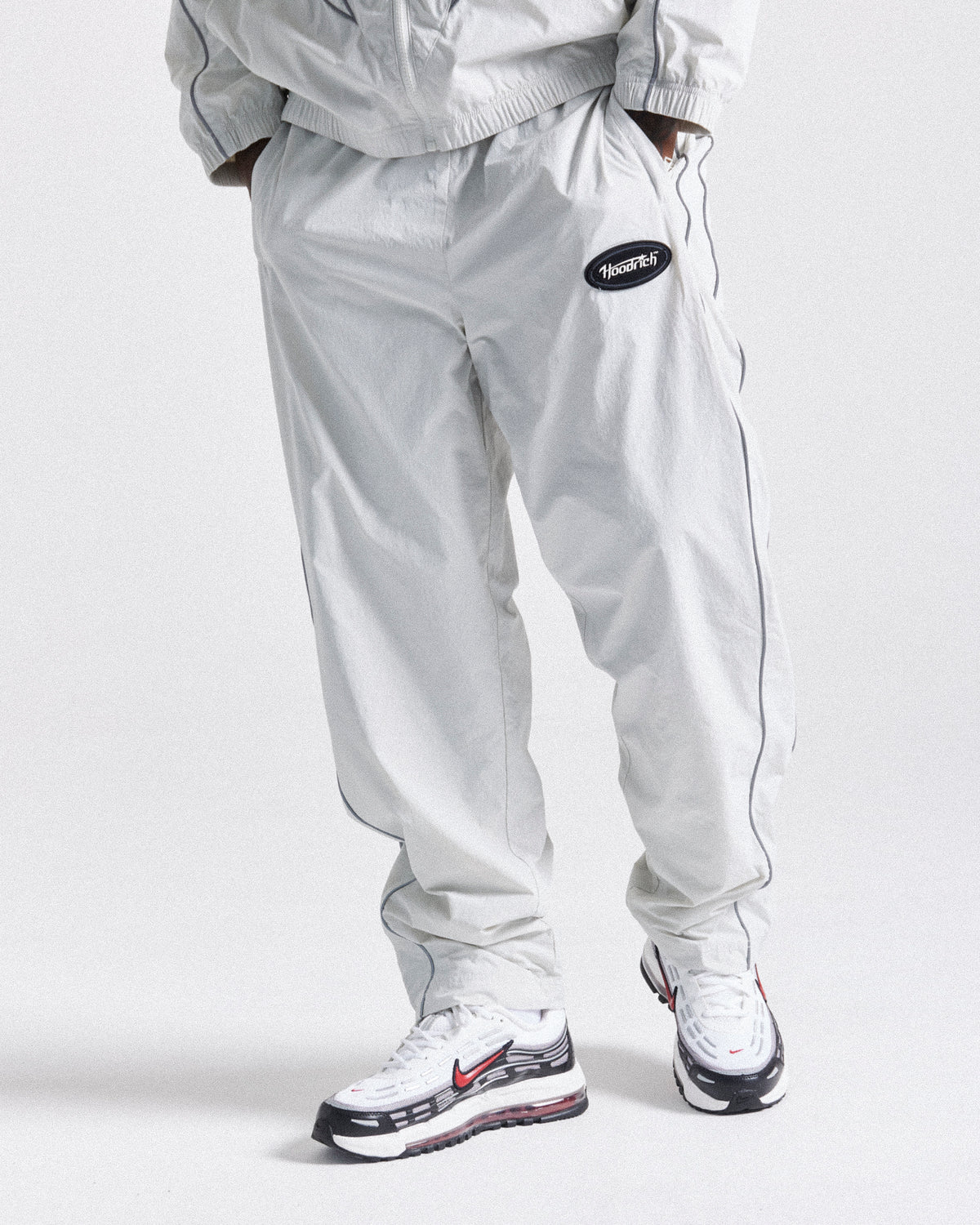 Displays a model wearing the Grey 'Hoodrich' branded men's Cypher Woven Full Tracksuit