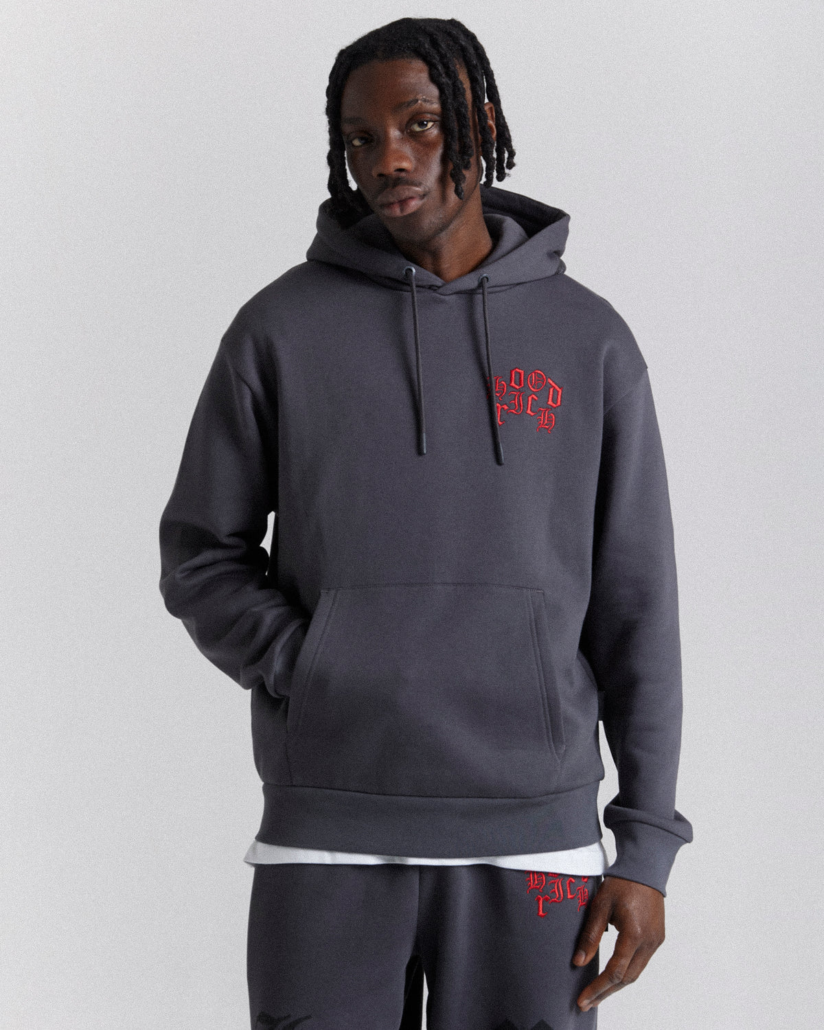 Displays a model wearing the Grey 'Hoodrich' branded men's Crown Full Tracksuit