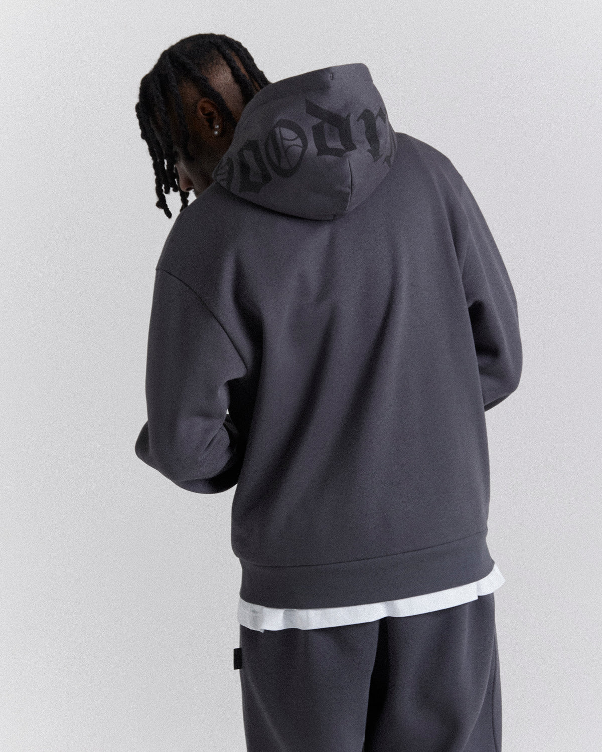 Displays a model wearing the Grey 'Hoodrich' branded men's Crown Full Tracksuit