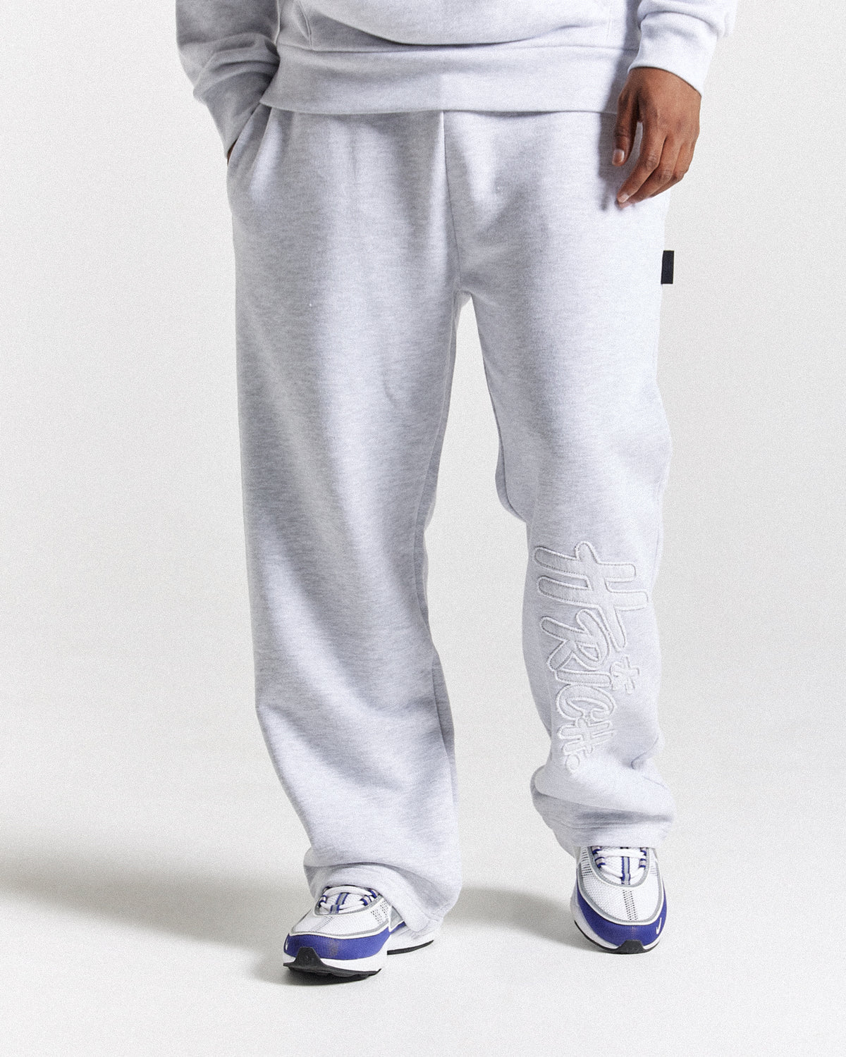 Displays a model wearing the light grey 'Hoodrich' branded men's Asthrich Full Tracksuit