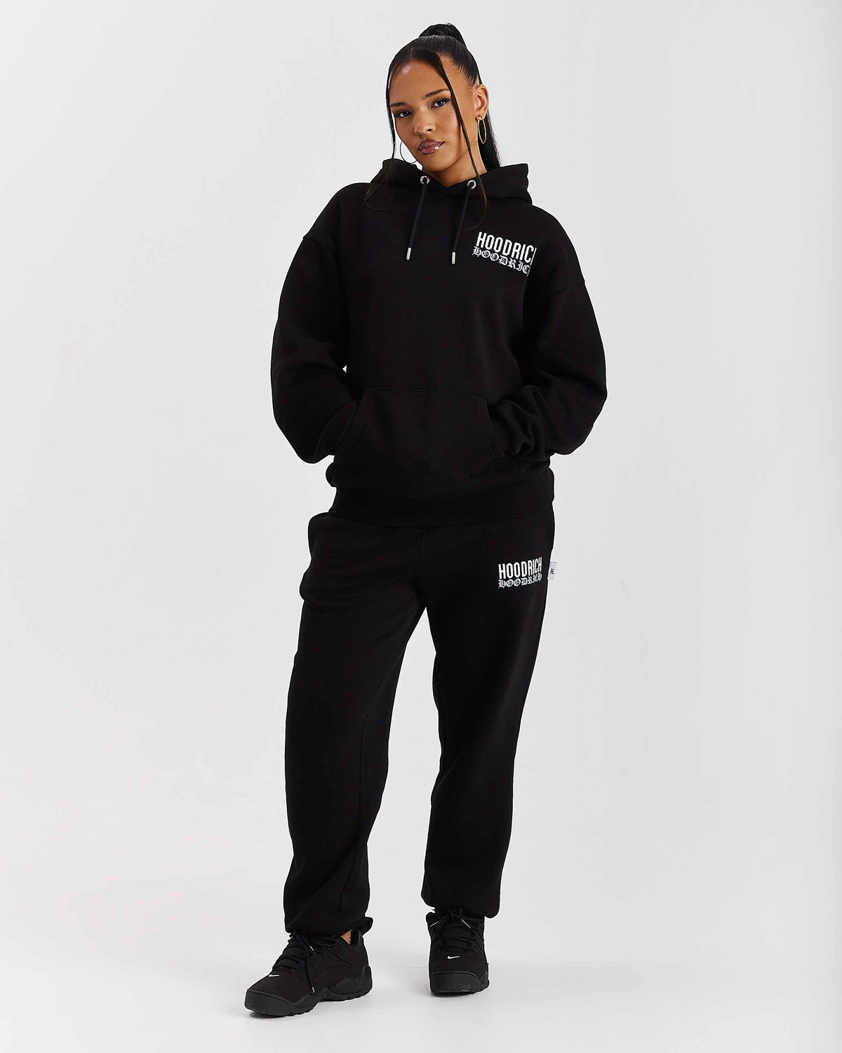Displays a model wearing the Black 'Hoodrich' branded women's Flex Full Tracksuit