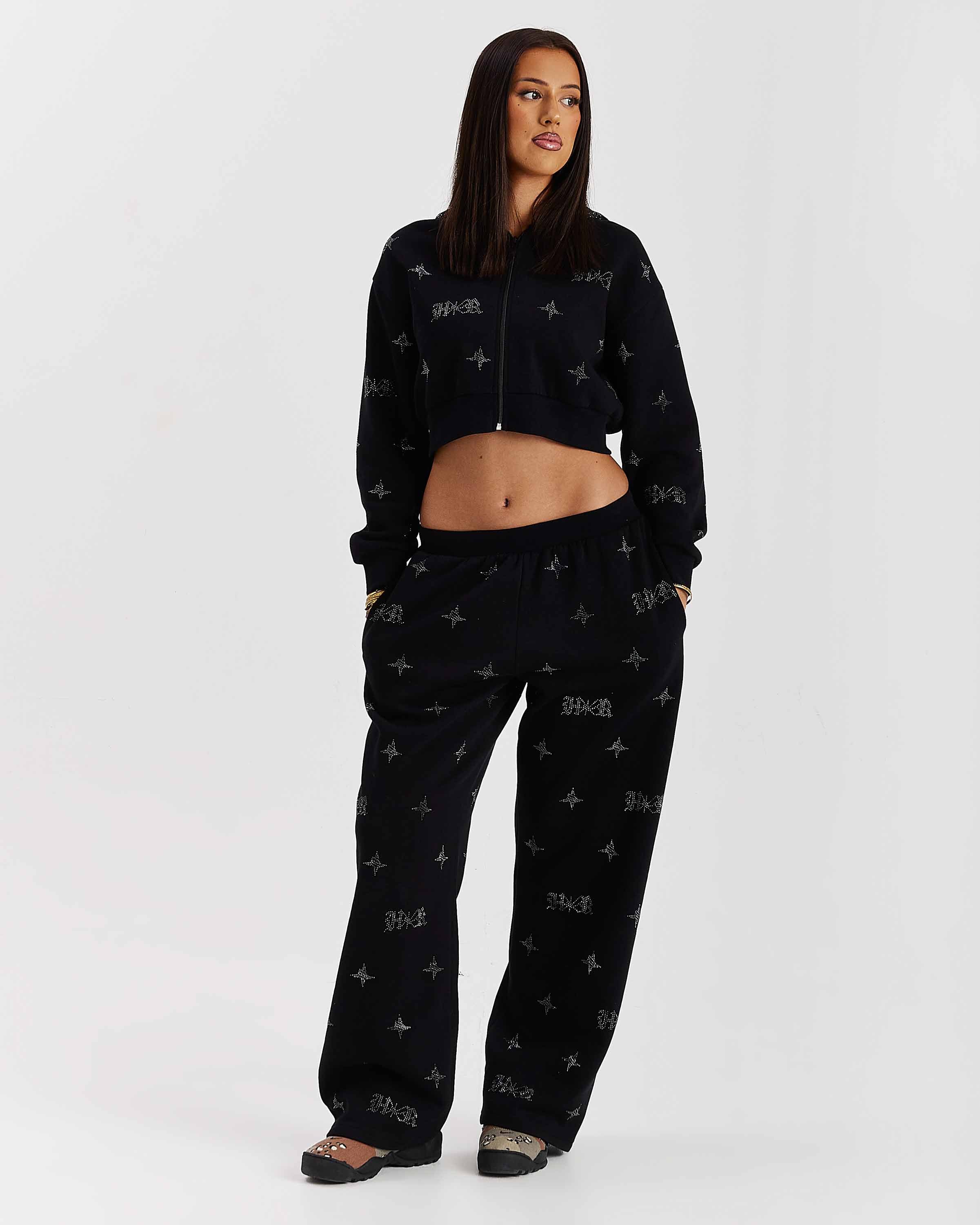 Woman wearing a black patterned outfit on a white background