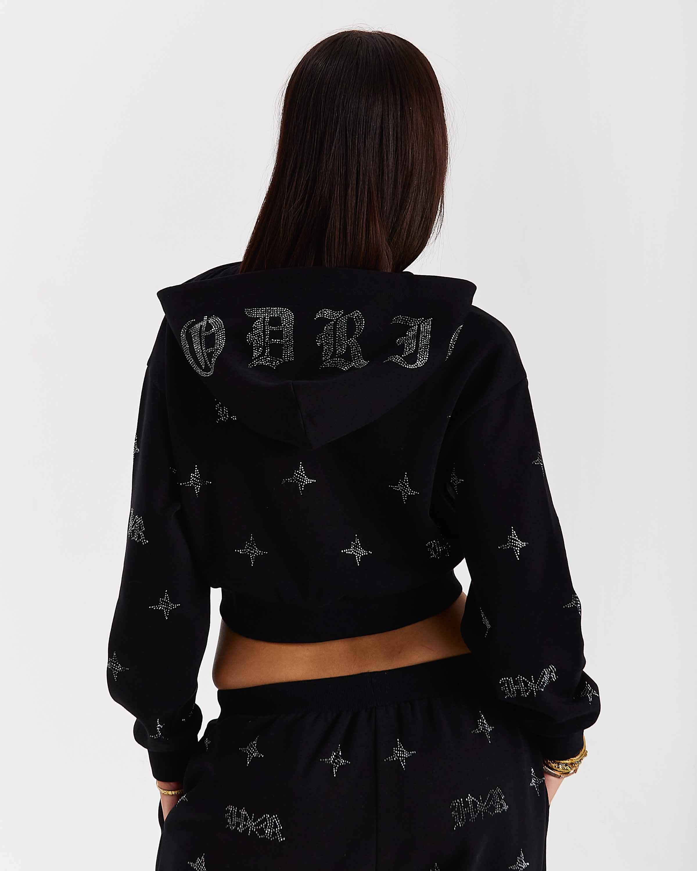 Person wearing a black hoodie with branding on the back against a white background