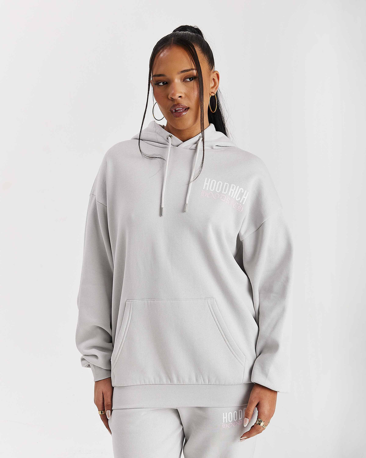 Displays a model wearing the Grey 'Hoodrich' branded women's Flex Full Tracksuit