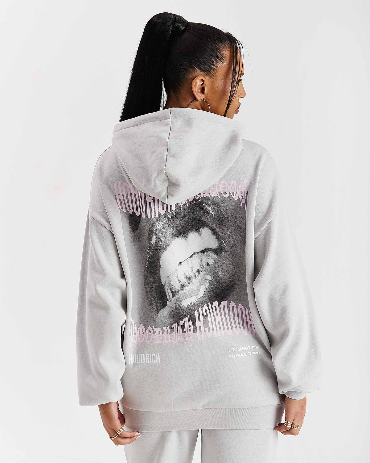 Displays a model wearing the Grey 'Hoodrich' branded women's Flex Full Tracksuit