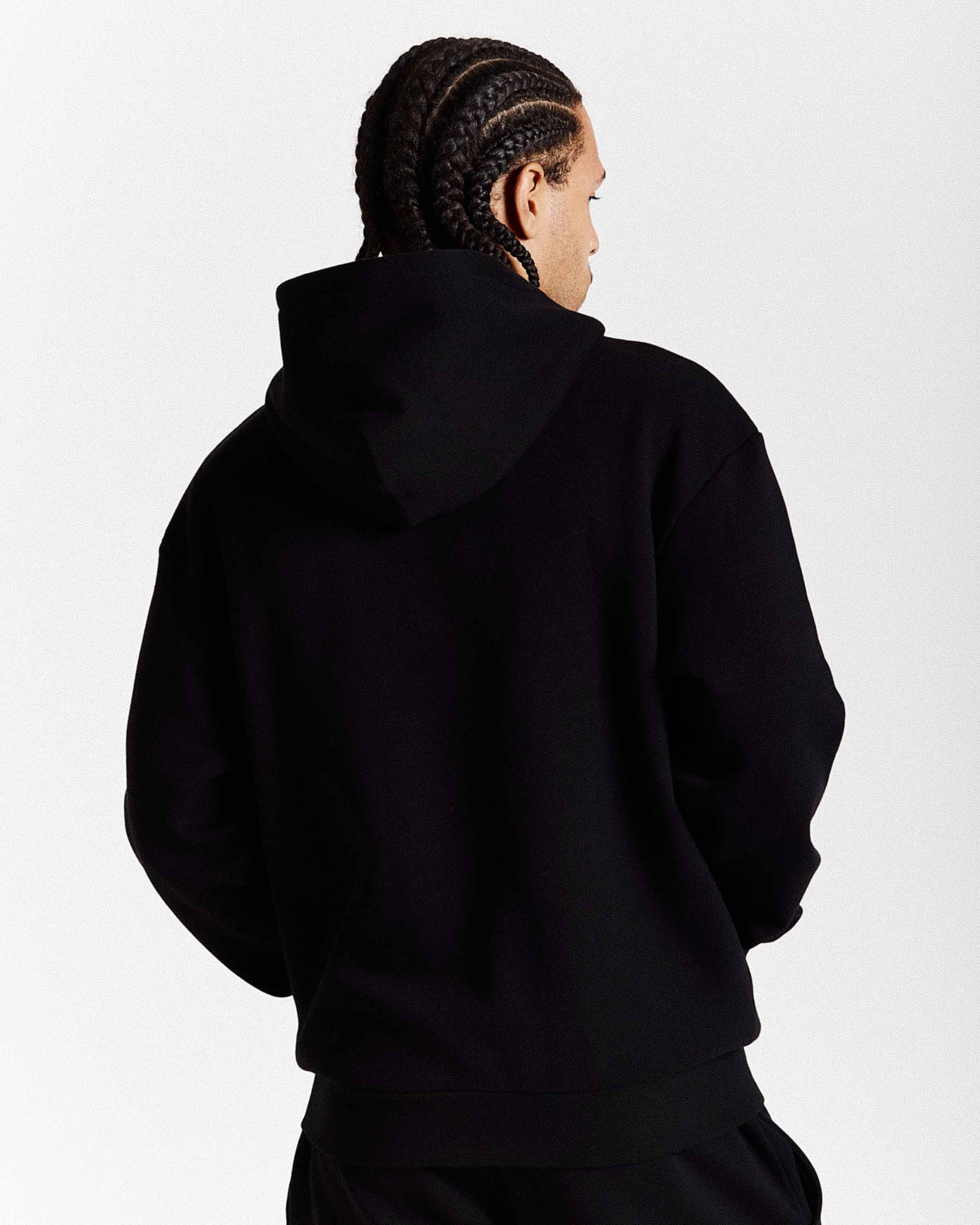 Person wearing a black hoodie from behind on a white background