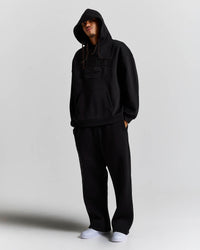 Displays a model wearing the Black 'Hoodrich' branded men's Aegis Full Tracksuit 