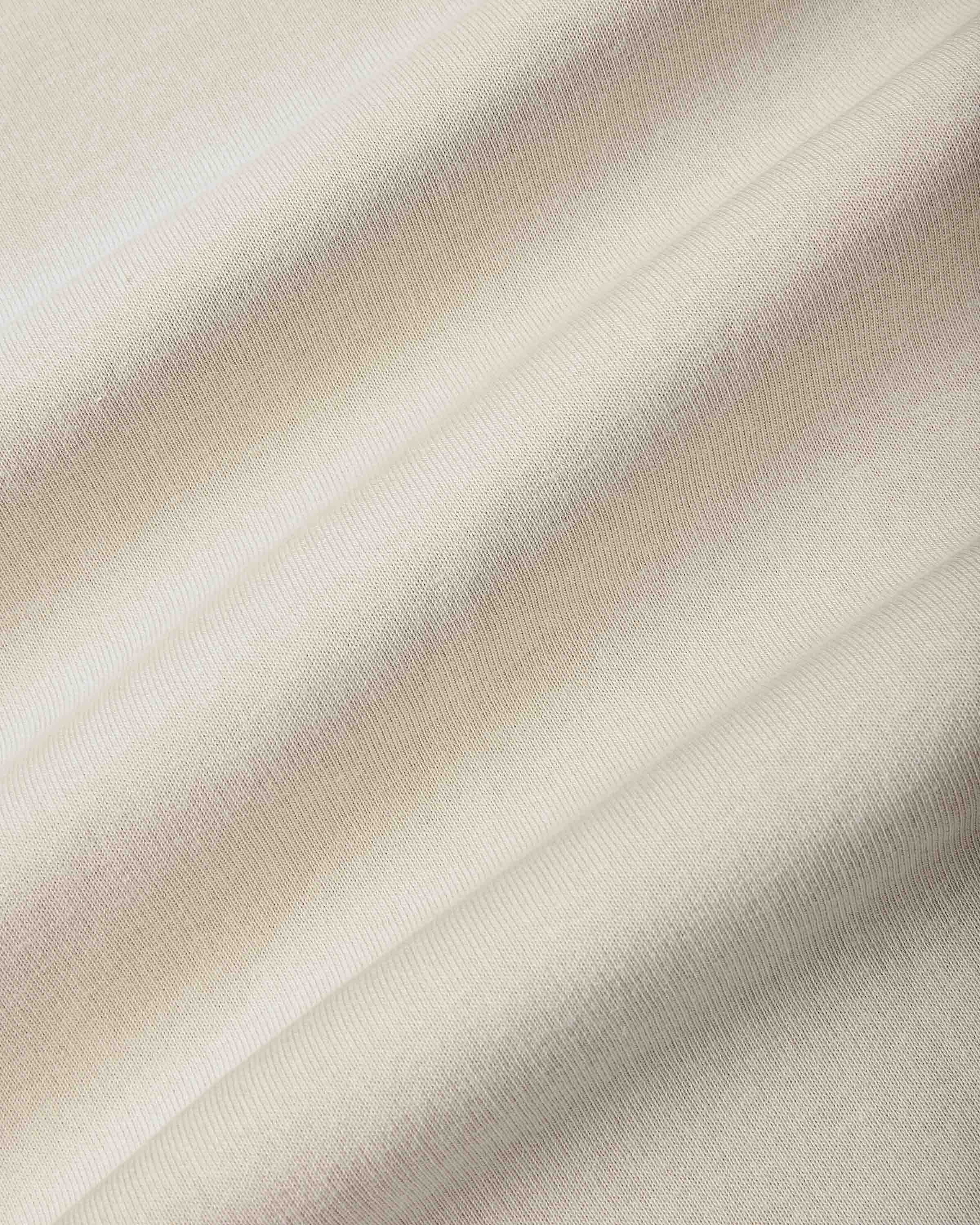 A close-up of draped fabric with a soft diagonal stripe pattern in cream, beige, and light pink.