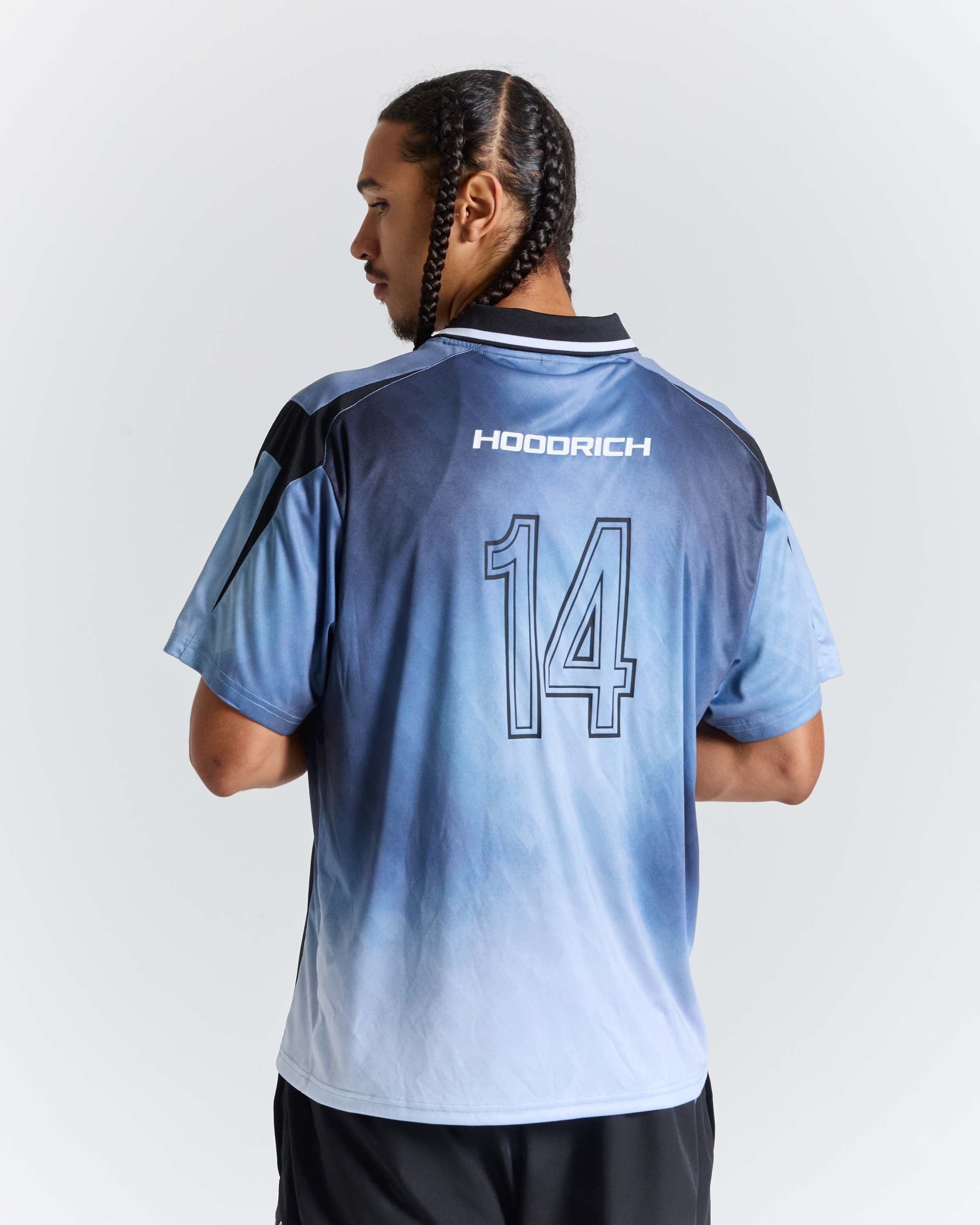 A man shown from the back wearing a light blue and white gradient soccer jersey with 'HOODRICH' and the number '14' printed on the back, set against a plain light gray background.