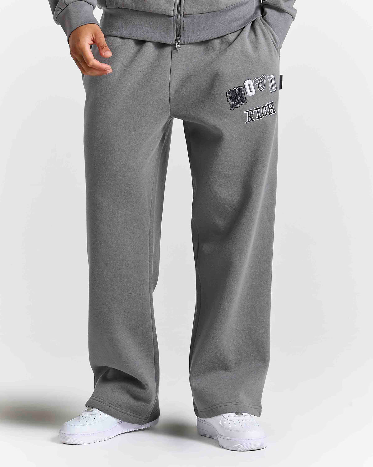 Displays a model wearing the Grey 'Hoodrich' branded men's Forza Full Tracksuit 