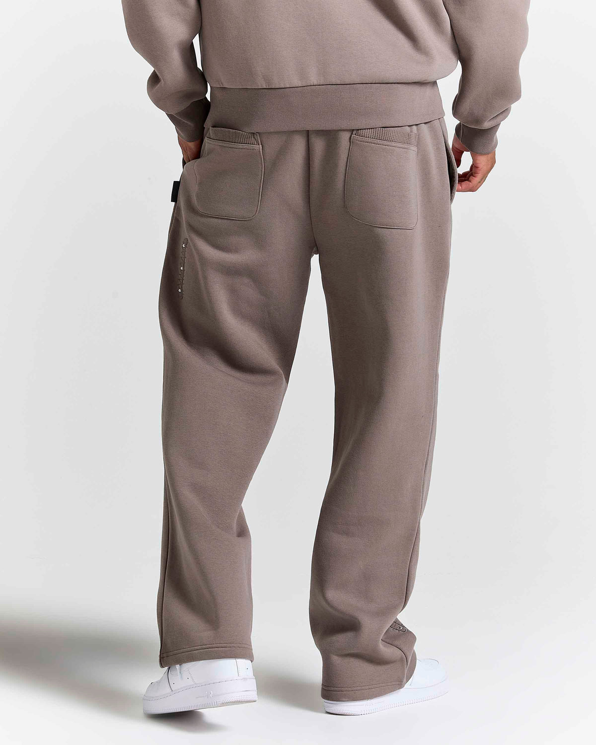 Displays a model wearing the Falcon Black 'Hoodrich' branded Varso Studs Oversized Wide Leg Jogger