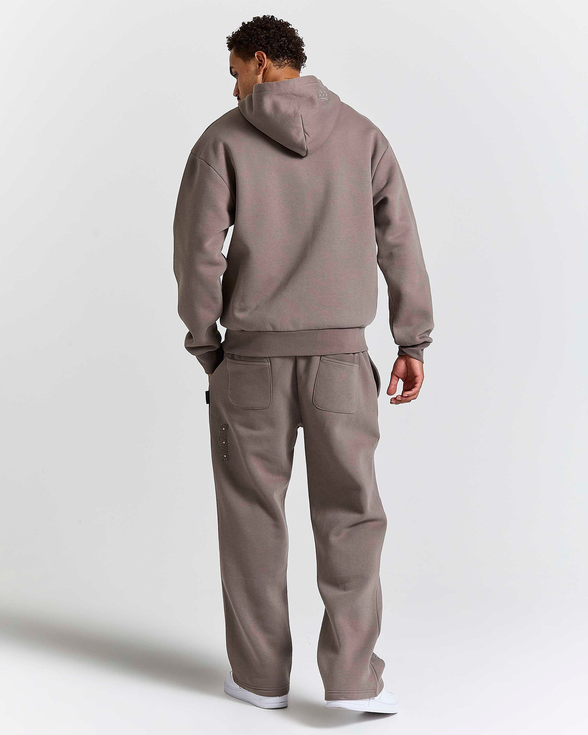 Displays a model wearing the Falcon Black 'Hoodrich' branded Varso Studs Oversized Wide Leg Jogger