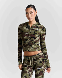 A model wearing a matching camouflage zip-up hoodie and jogger pants set with white HOODRICH branding, photographed against a light gray studio background.