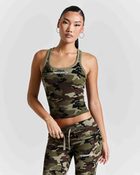 A woman modeling a matching camouflage activewear set consisting of a scoop-neck crop tank top and jogger-style pants with white drawstrings and a white 'HOODRICH' logo on the chest.