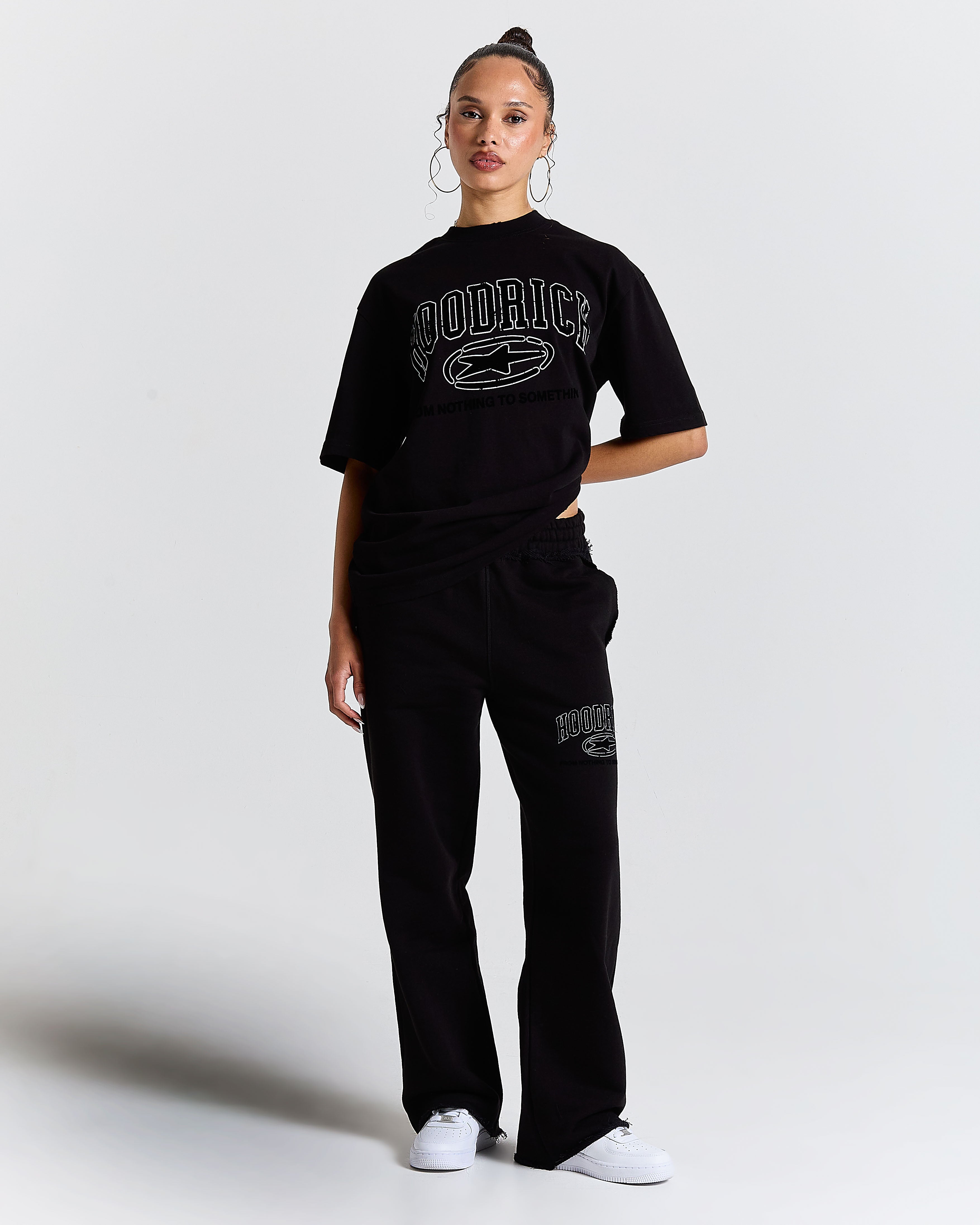 Front view of a female model wearing a regular-fit black Hoodrich t-shirt.
