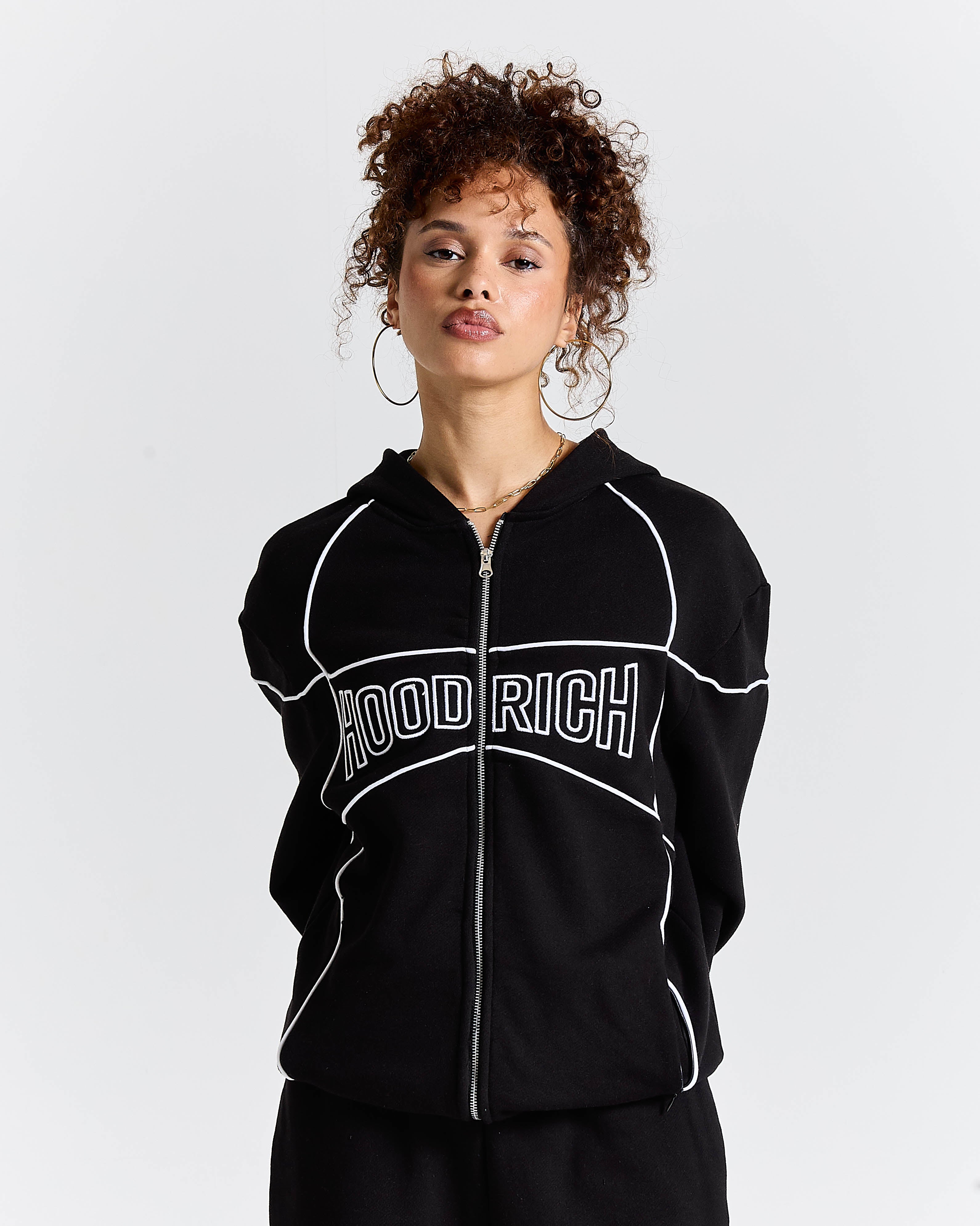 Person wearing a black hoodie with 'HOODRICH' text on a white background