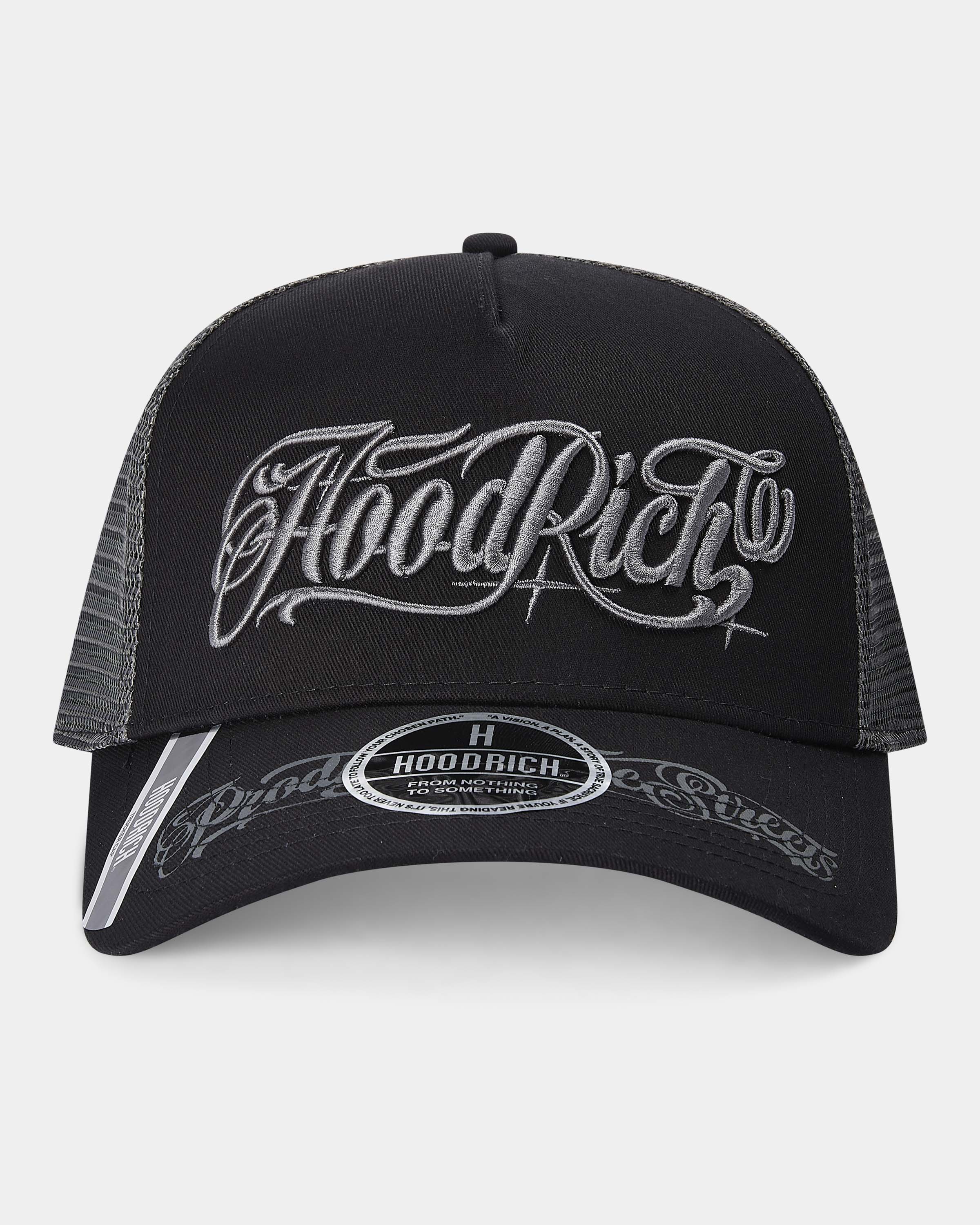 Black and gray trucker cap with 'Hood Rich' branding on a light gray background