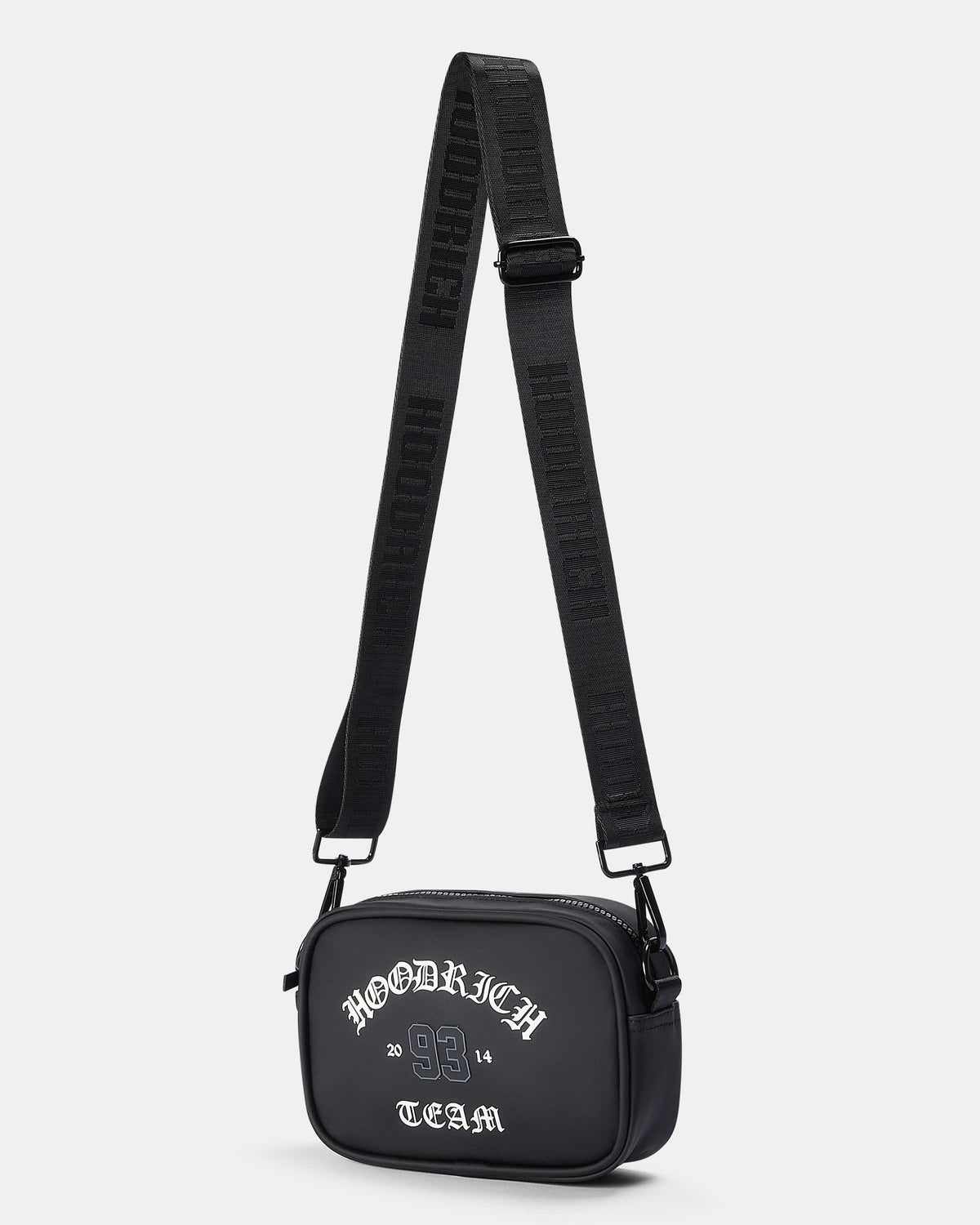 A black rectangular crossbody bag with a wide, textured black shoulder strap, featuring white gothic-style text on the front that reads 'HOODRICH TEAM'. The bag is photographed on a clean, light gray background.