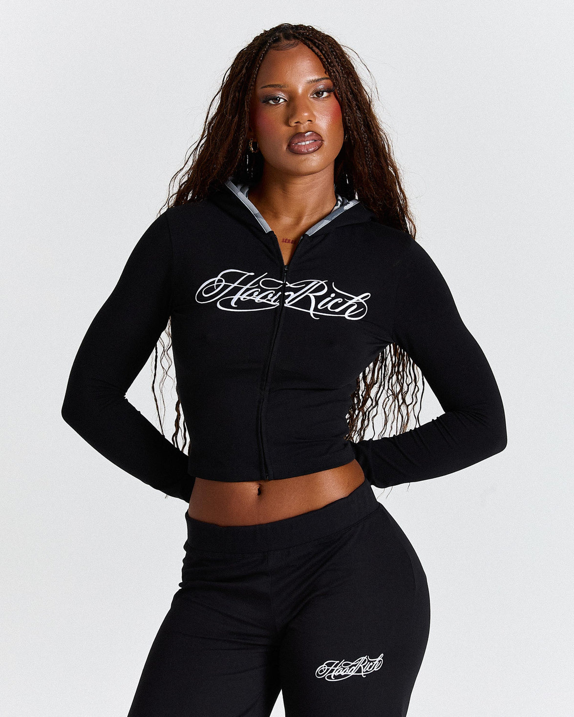 Woman wearing a black hoodie with 'Hoodrich' branding on a white background