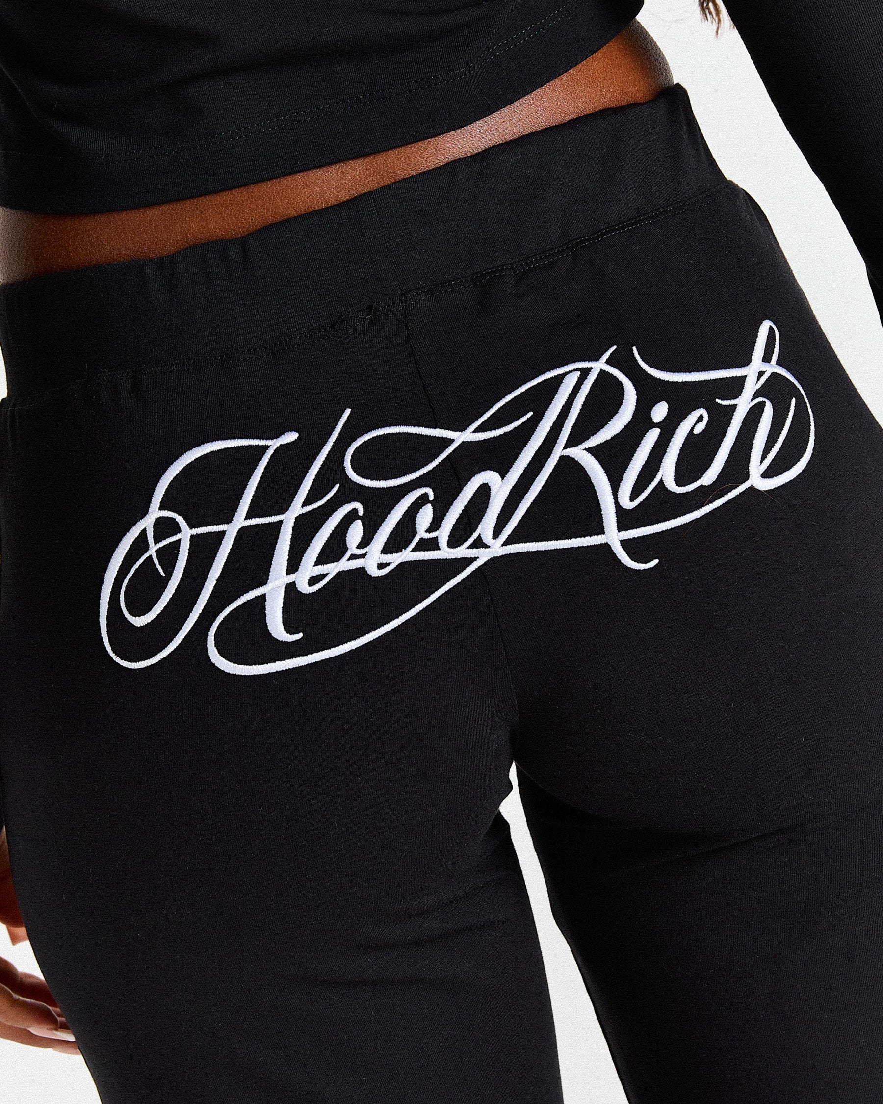 Black pants with 'Hood Rich' text on a white background