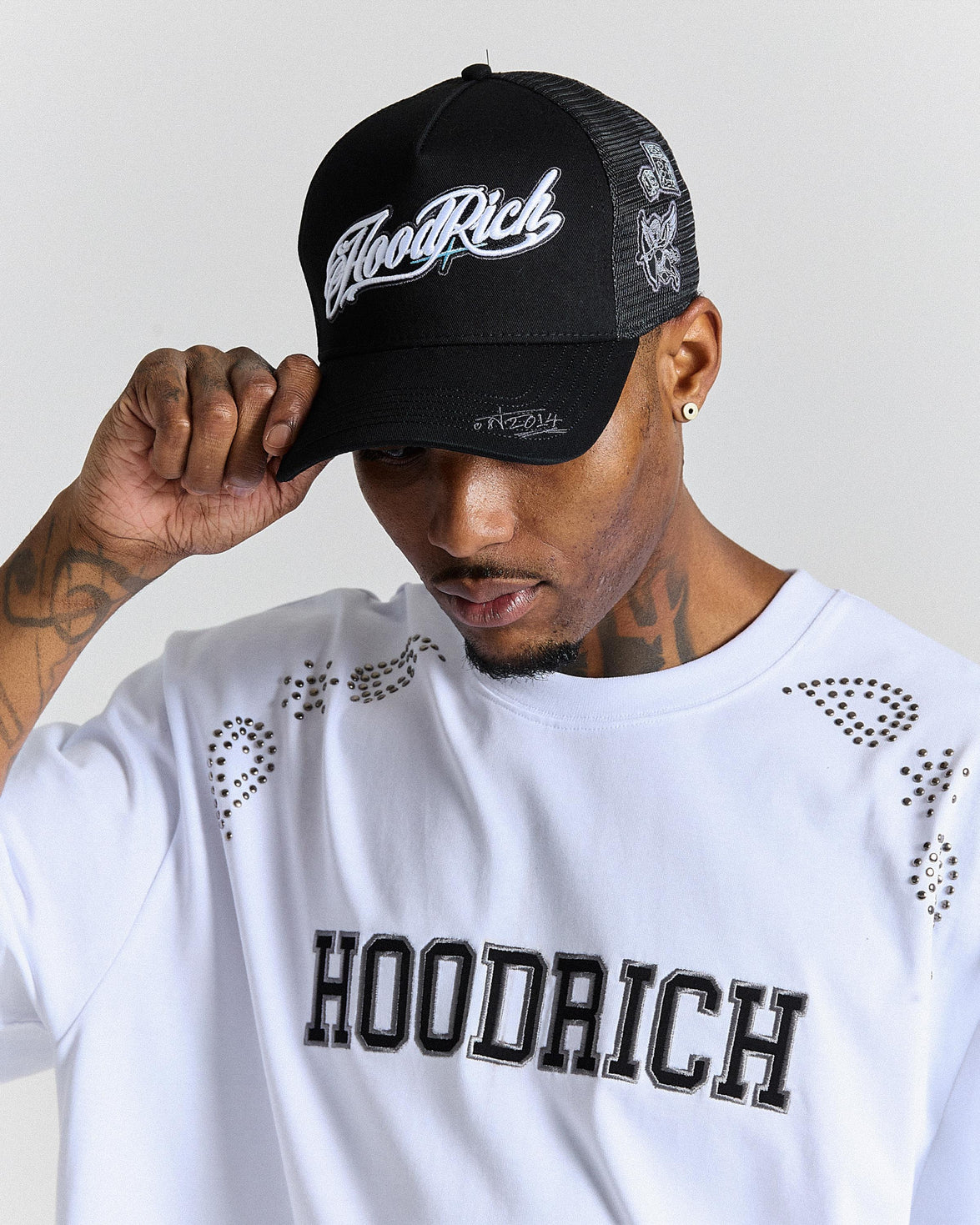 Person wearing a black cap with 'Hoodrich' branding and a matching white t-shirt.