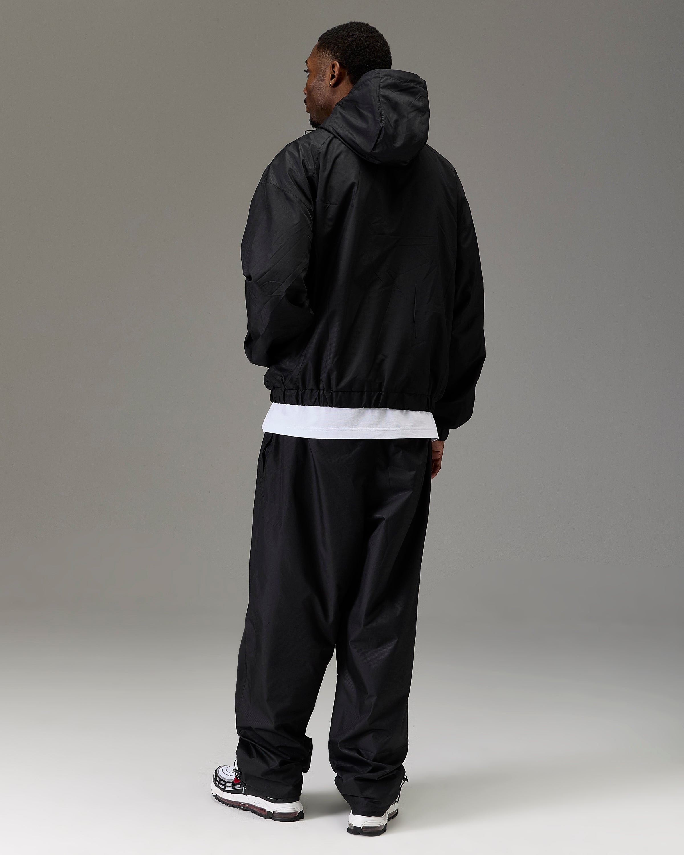 Displays a model wearing the Black 'Hoodrich' branded Men's The Winner's Circle Ripstop Woven Full Tracksuit