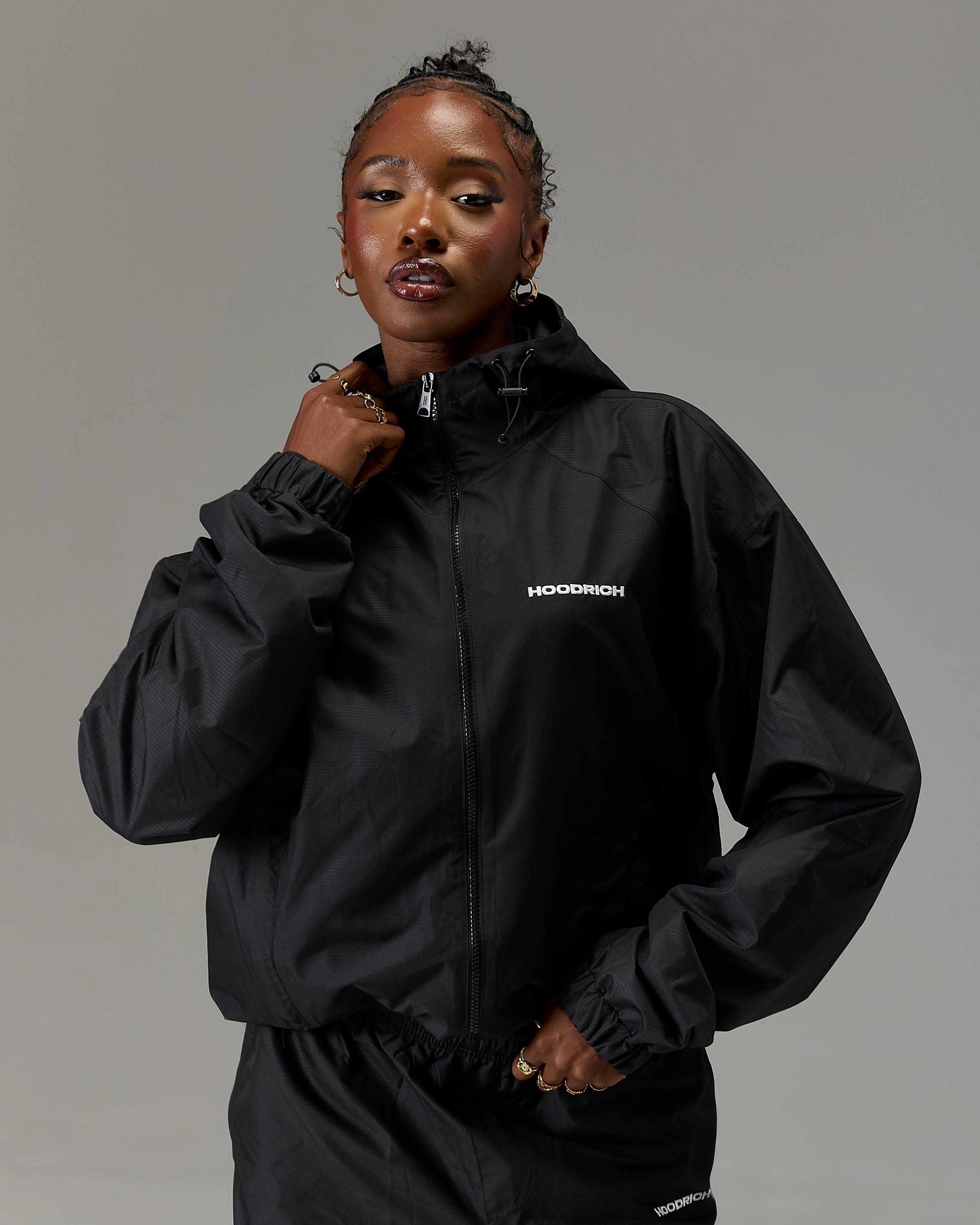 Displays a model wearing the Black 'Hoodrich' branded women's The Winner's Circle Ripstop Woven Full Tracksuit