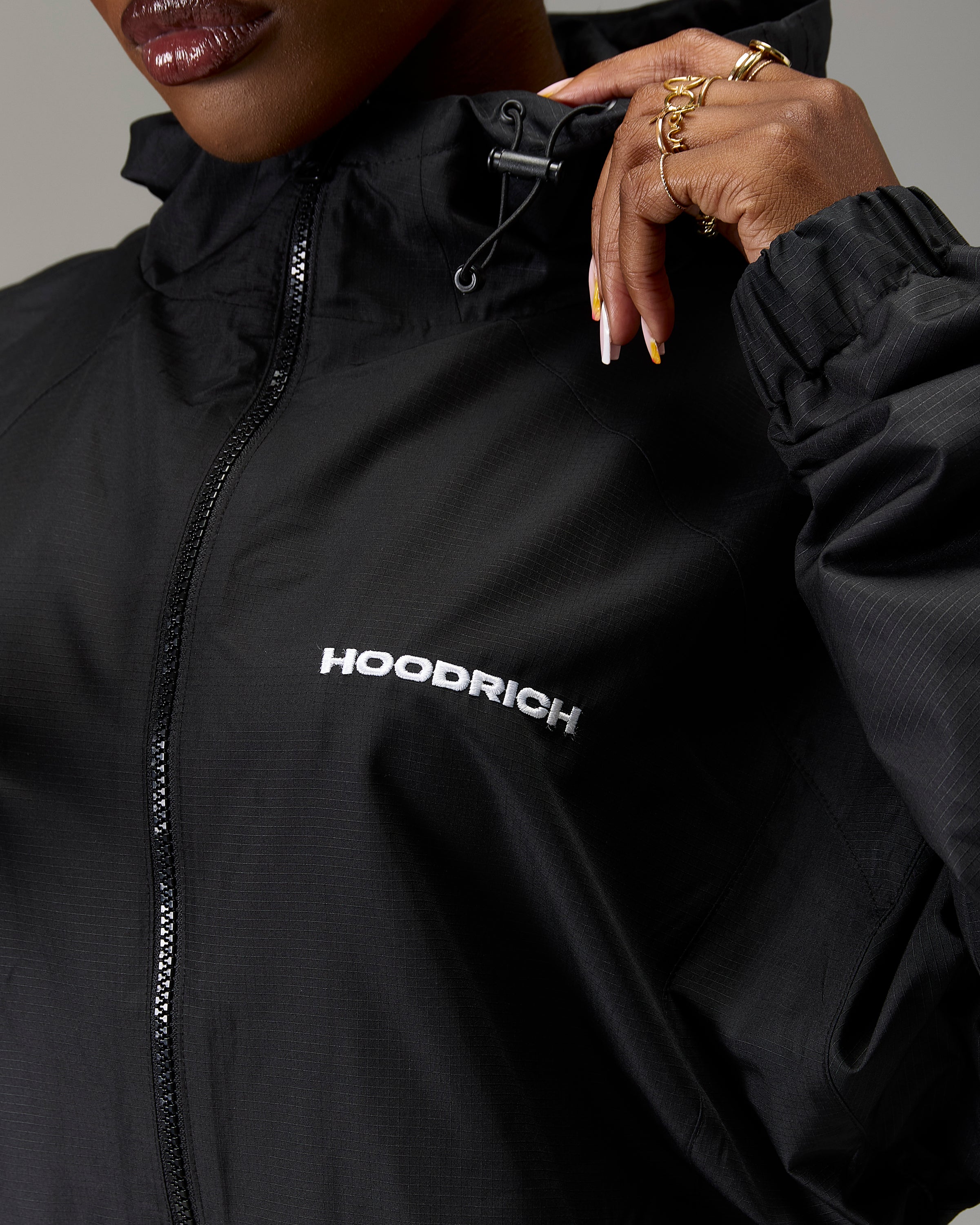 Displays a model wearing the Black 'Hoodrich' branded women's The Winner's Circle Ripstop Woven Full Tracksuit