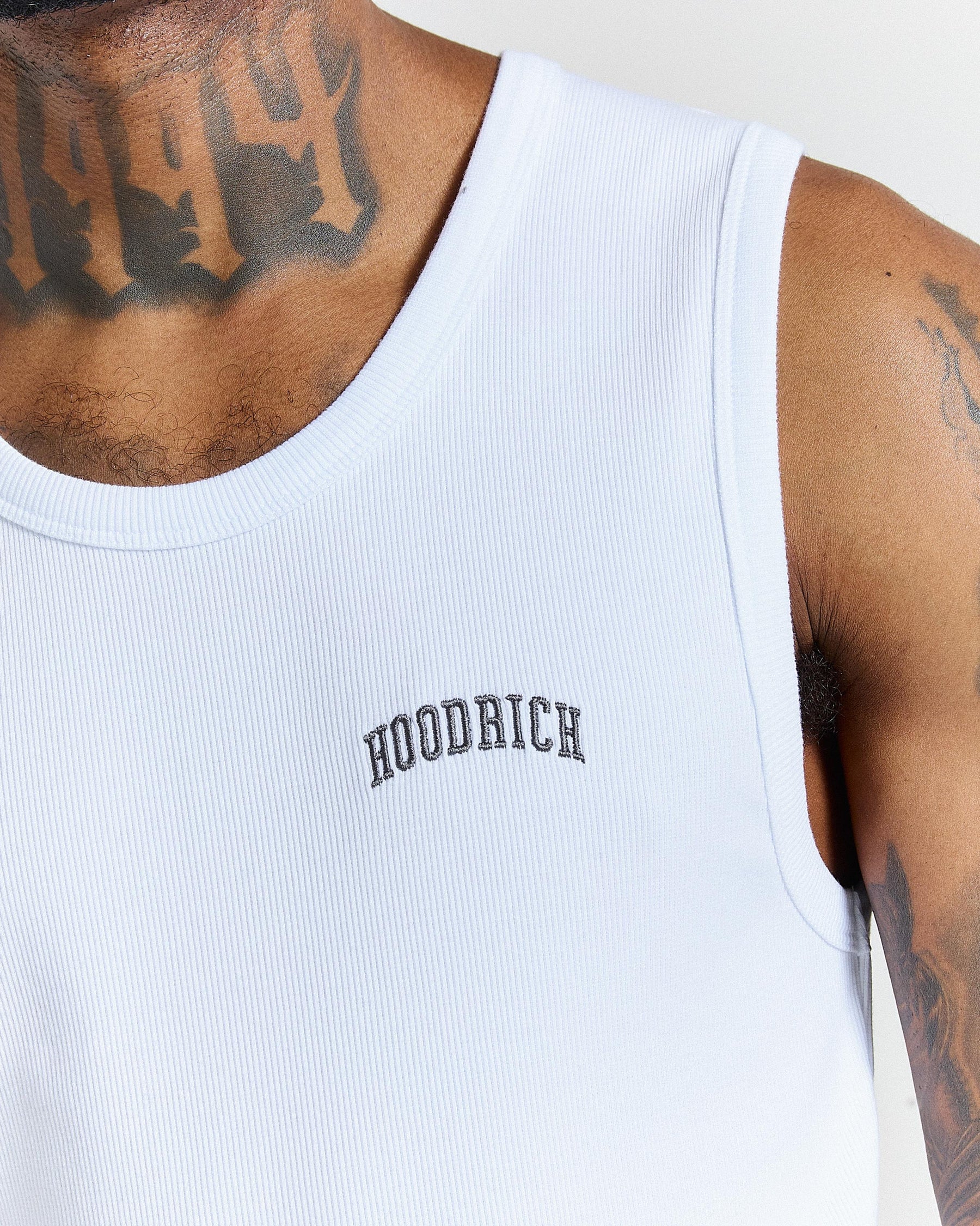White tank top with 'Hoodrich' branding on a person wearing it.
