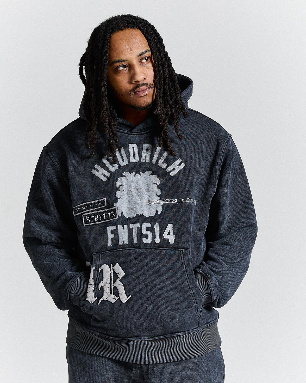 Person wearing a dark hoodie with text and graphics on a white background
