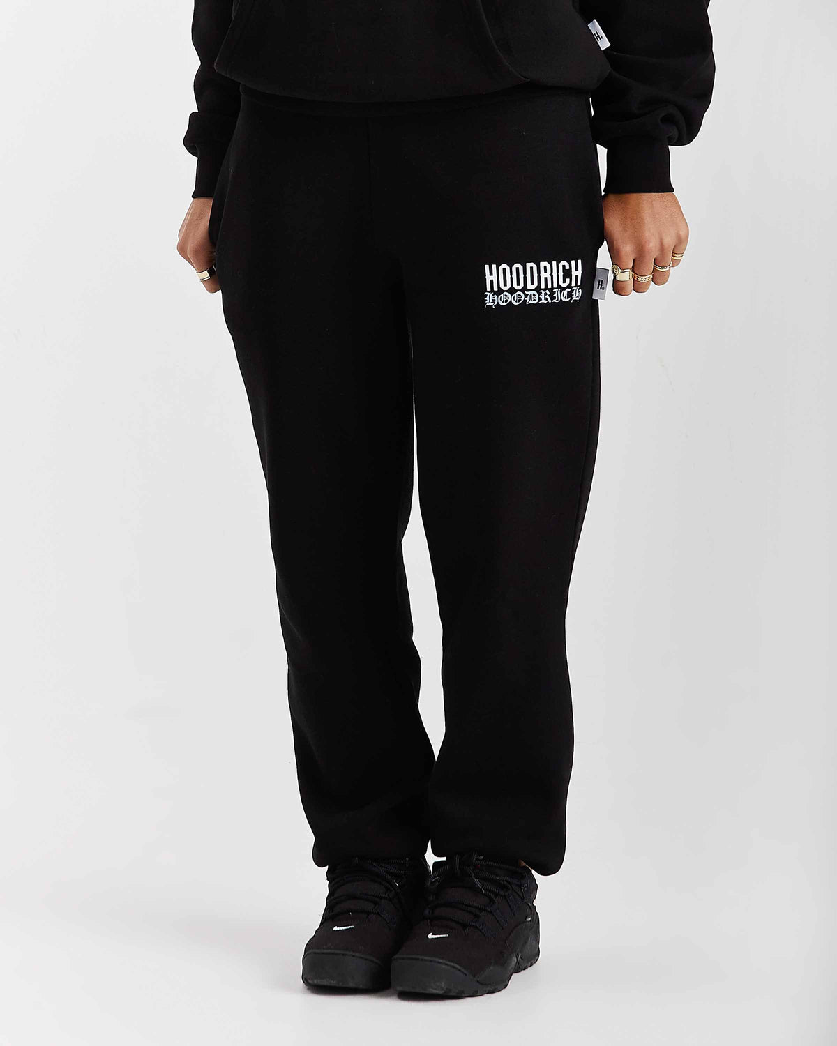 Displays a model wearing the Black 'Hoodrich' branded women's Flex Full Tracksuit 
