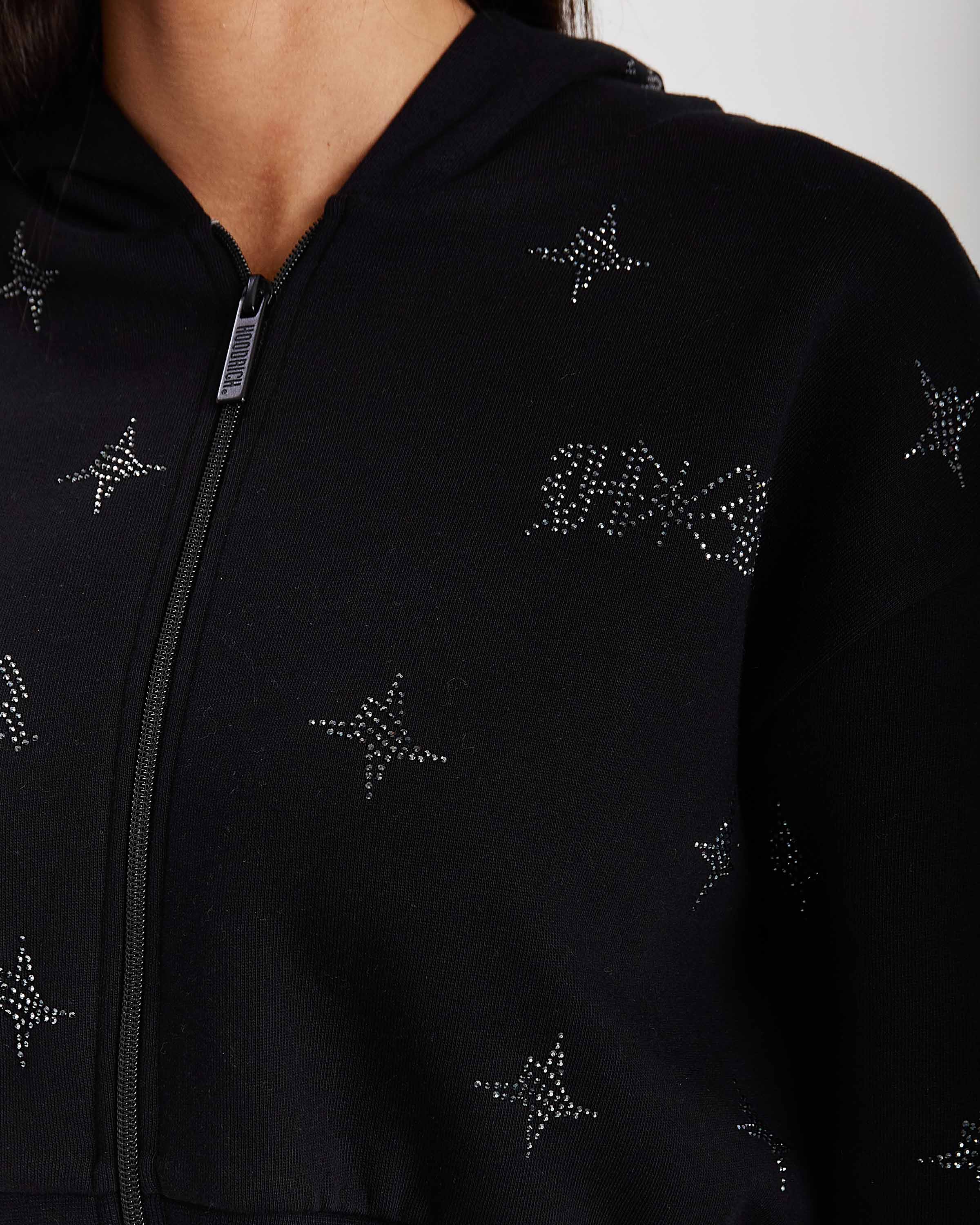 Black hoodie with star patterns on a plain background