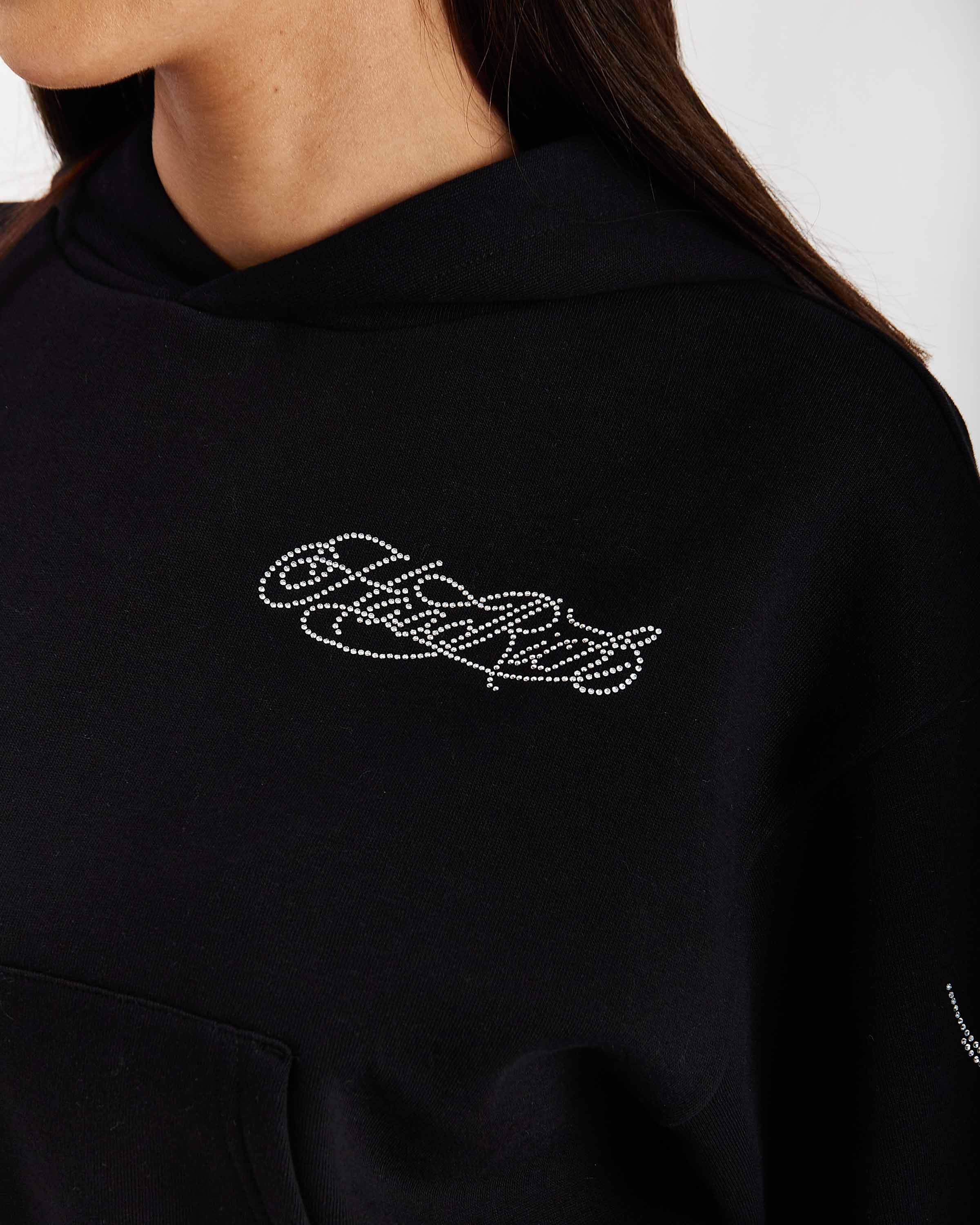 Black hoodie with rhinestone embellishments on a white background