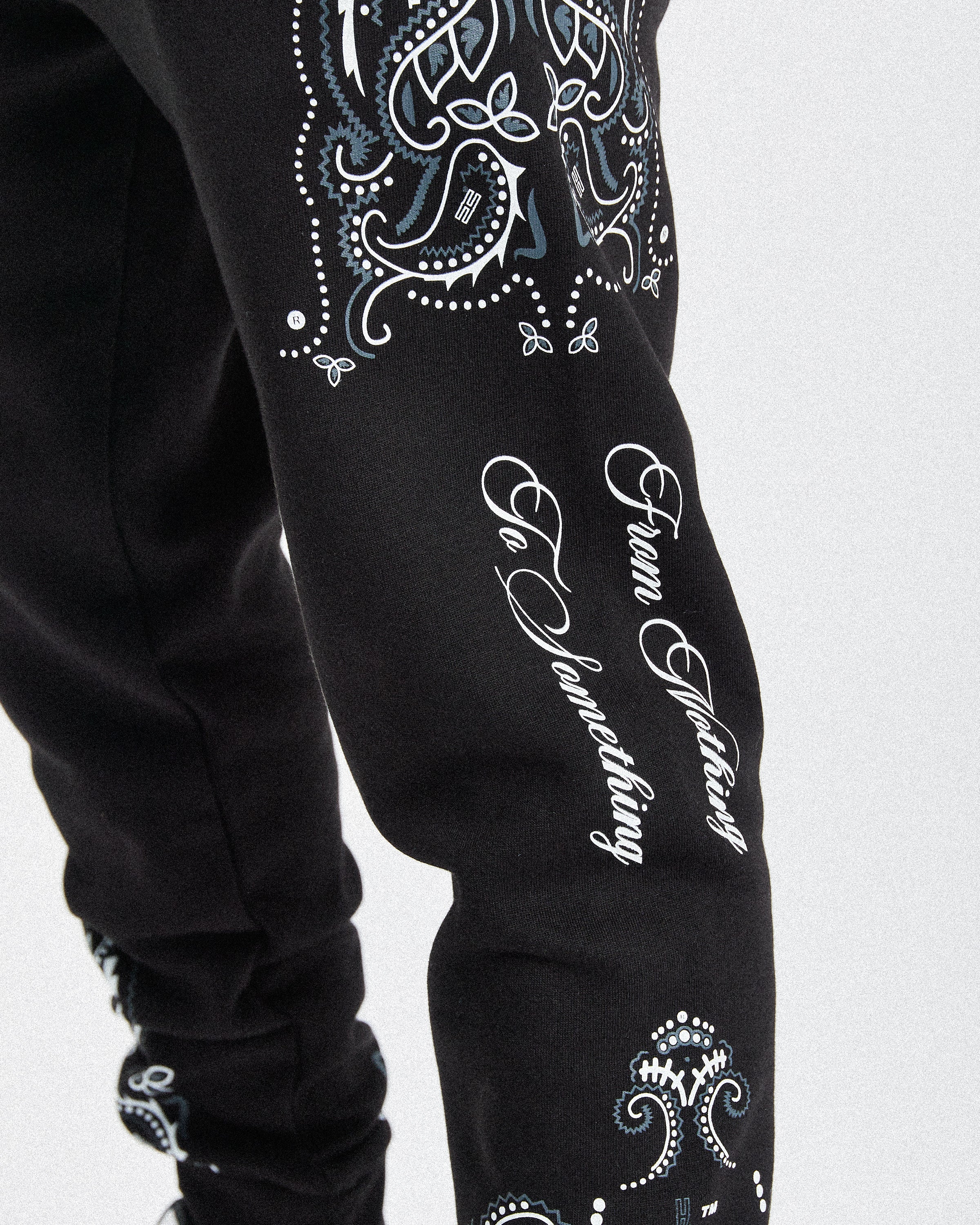 Displays a model wearing the black 'hoodrich' branded men's Motif Full Tracksuit 